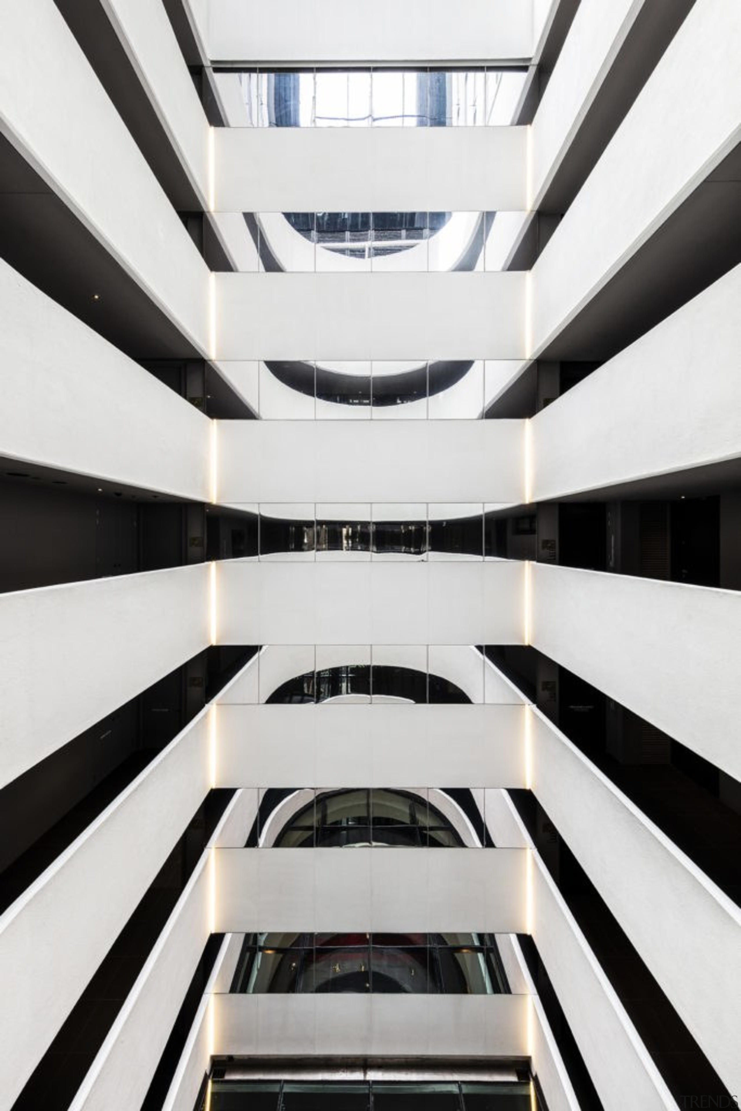 The dramatic residential lobby is decorated with reference architecture, black-and-white, building, commercial building, daylighting, design, facade, line, mixed-use, monochrome, parallel, pattern, sky, symmetry, white, white, black, atrium