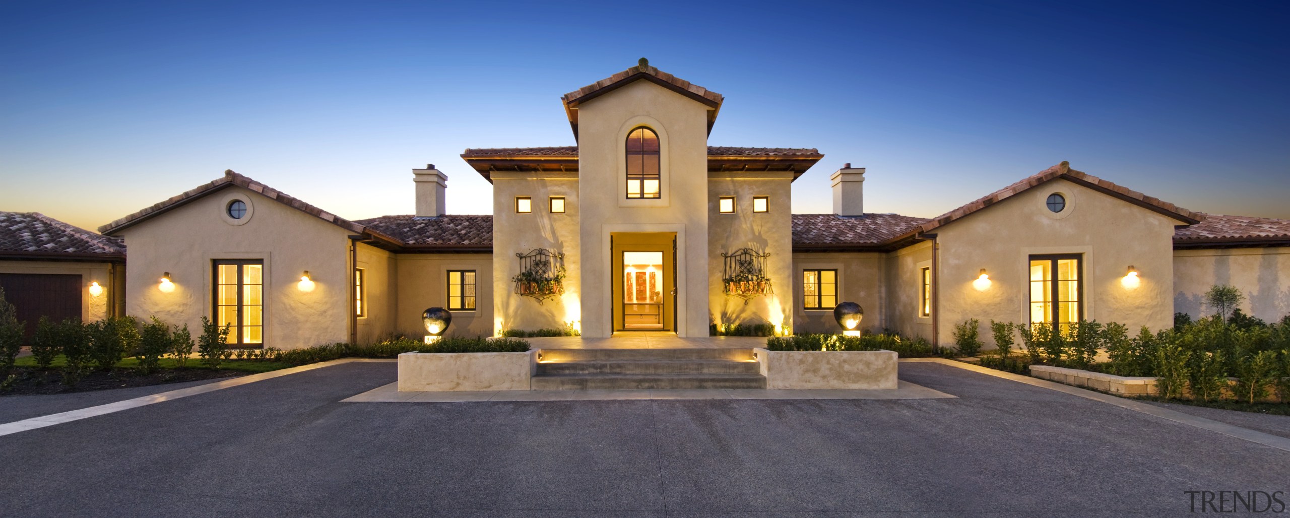 A snse of symmetry defines the front entrance. building, elevation, estate, facade, home, house, landscape lighting, lighting, mansion, property, real estate, residential area, sky