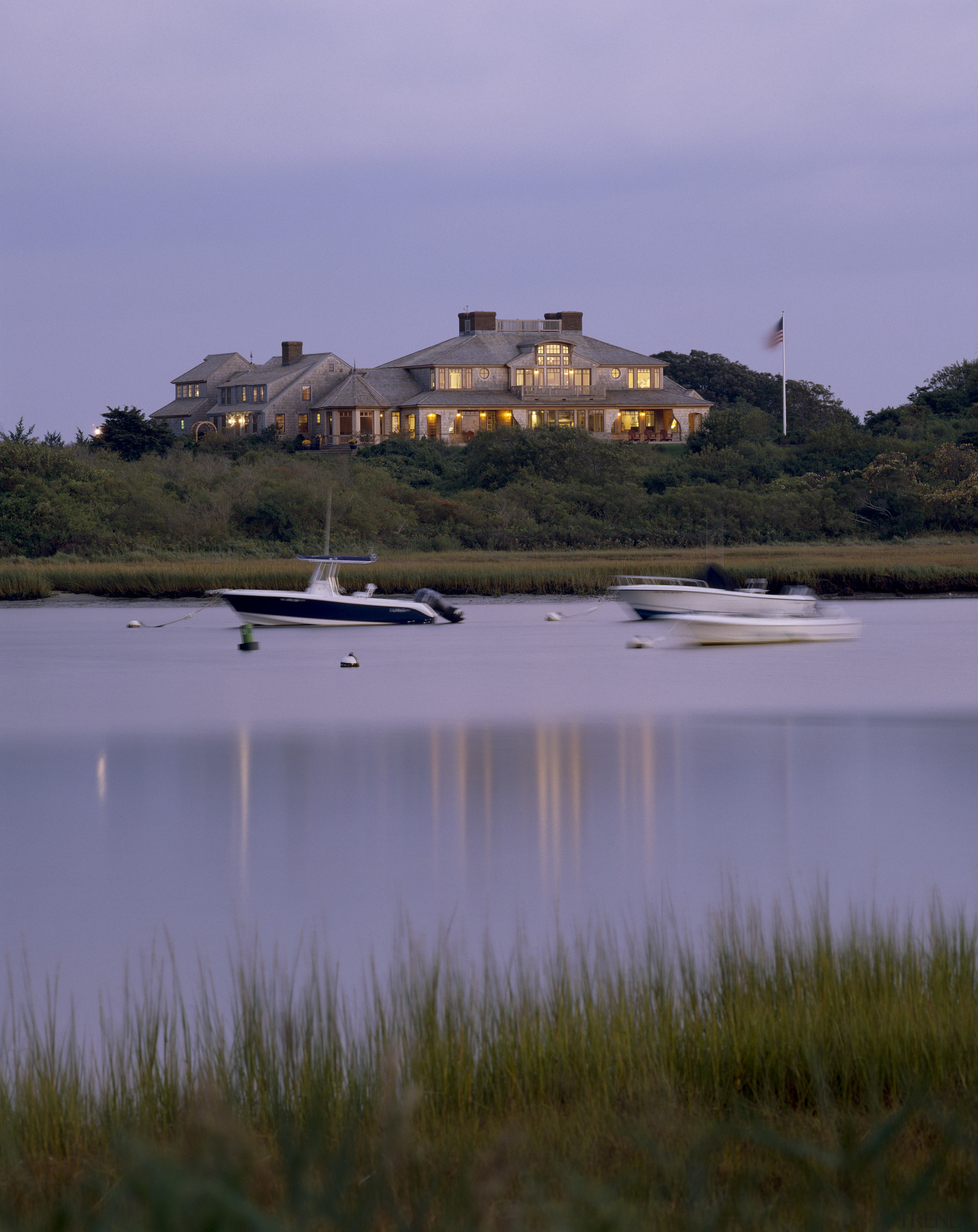 Exterior view of a large cottage with cedar bank, calm, coast, dawn, dusk, evening, grass, lake, landscape, loch, marsh, morning, reflection, reservoir, river, sea, shore, sky, tree, water, waterway, wetland, purple