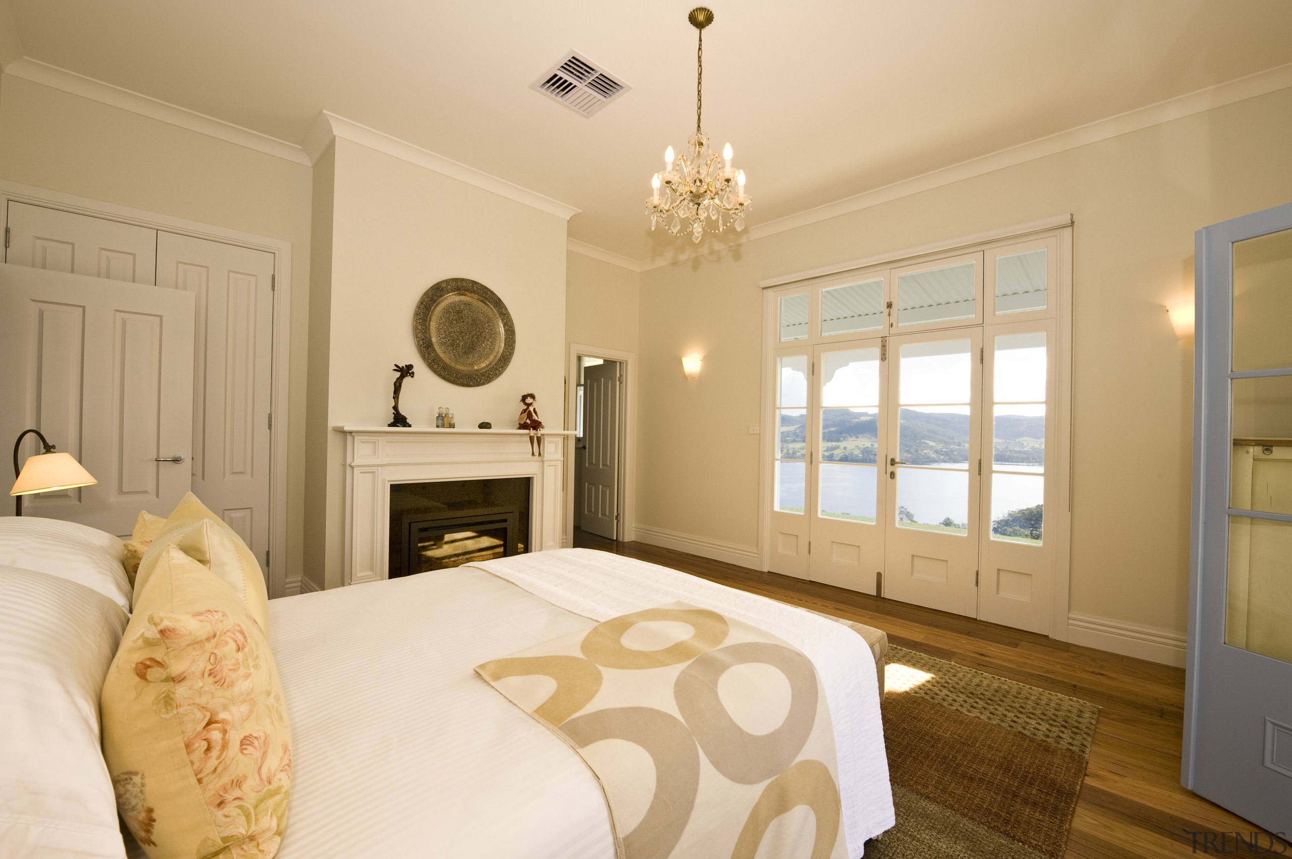 View of bedroom with chandelier, wooden flooring, rug, bed frame, bedroom, ceiling, estate, floor, home, interior design, property, real estate, room, suite, wall, window, orange