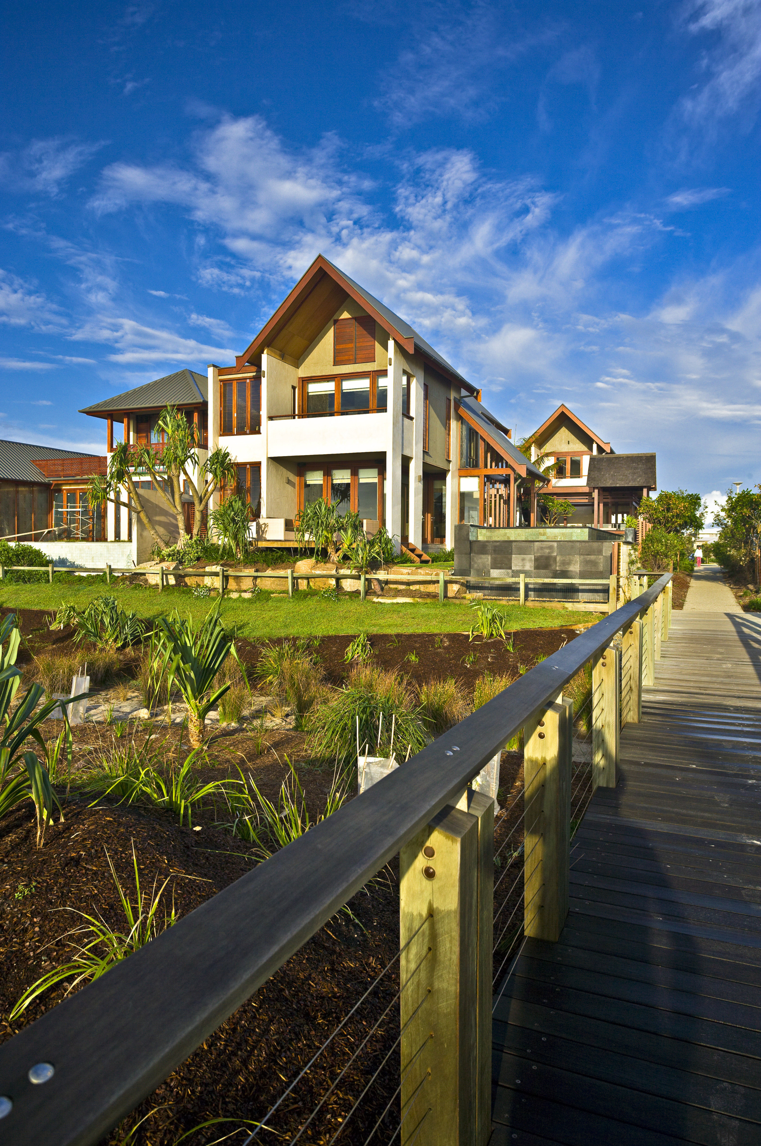 Exterior view of home, claddding, landscaping, doors and cottage, estate, home, house, property, real estate, reflection, residential area, resort, sky, villa, water