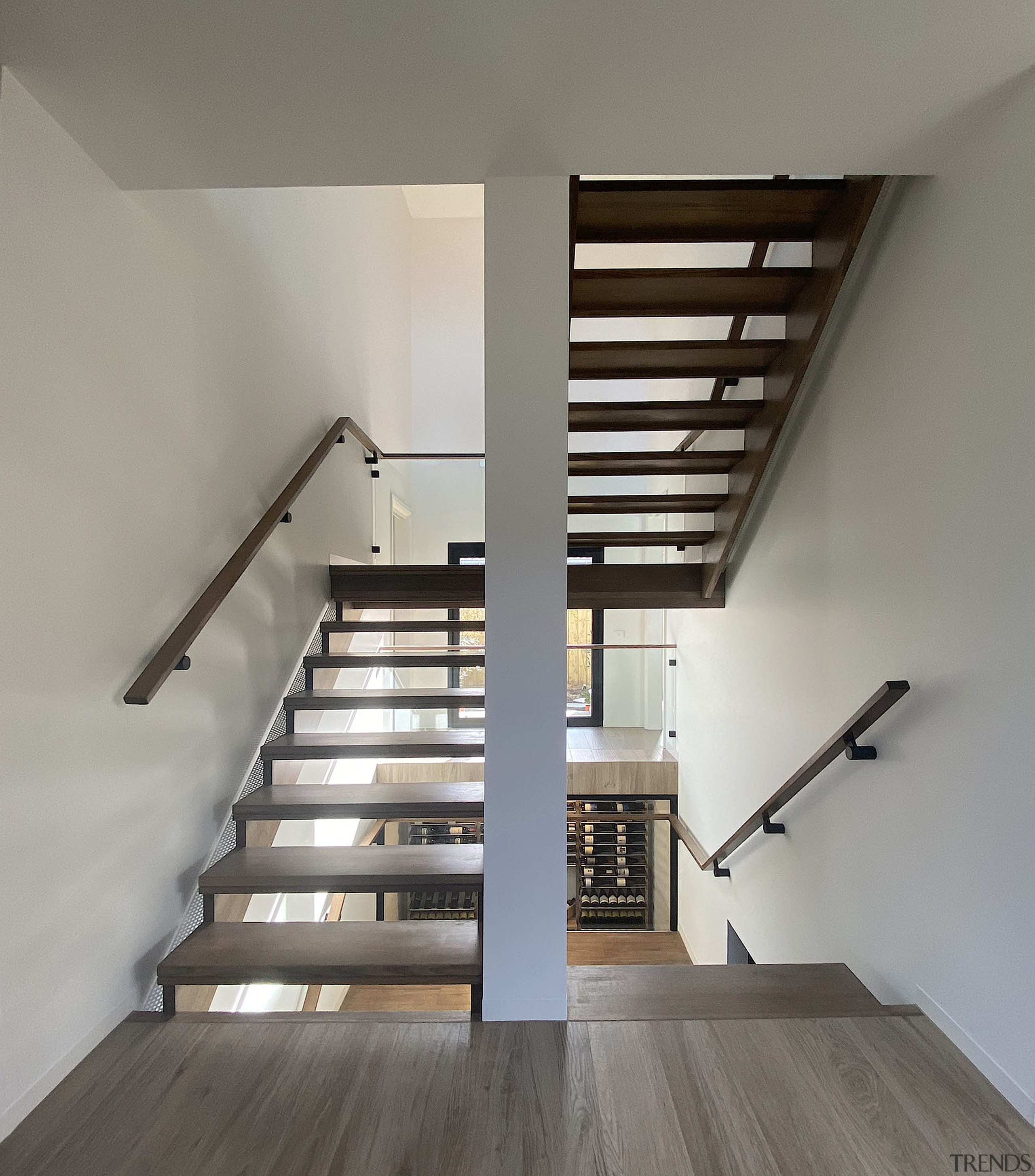 Stairs heading to basement level with wine cellar 