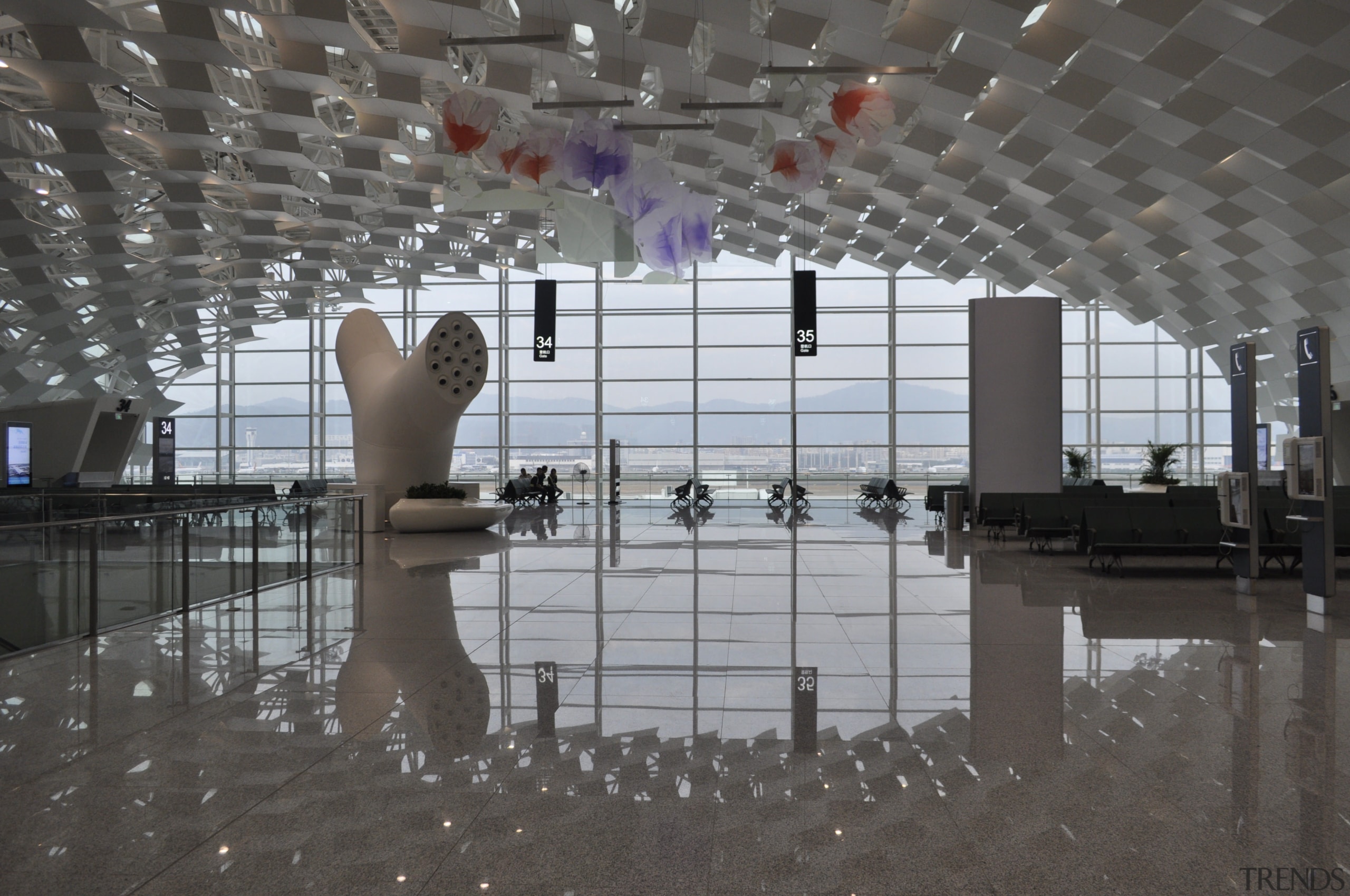 Looking much like a giant sculpture from both airport terminal, architecture, ceiling, daylighting, floor, flooring, interior design, lobby, reflection, structure, tourist attraction, water, gray, black