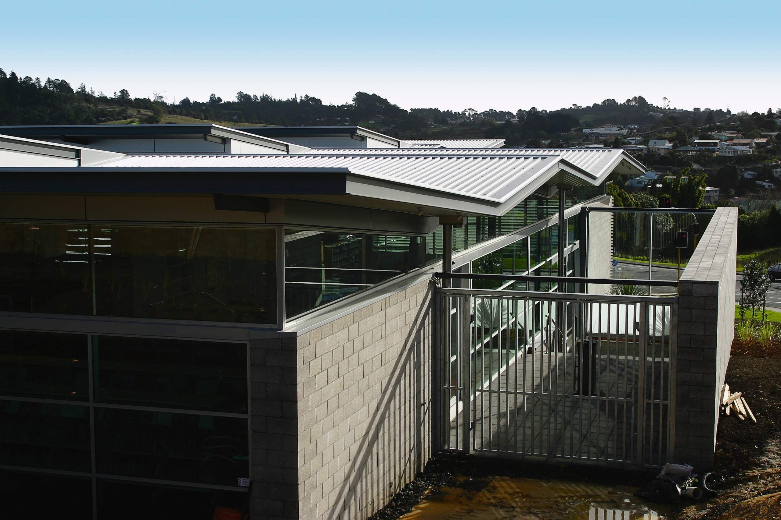 Exterior view of building with brick cladding, windows facade, fence, home, house, property, real estate, residential area, roof, shed, black