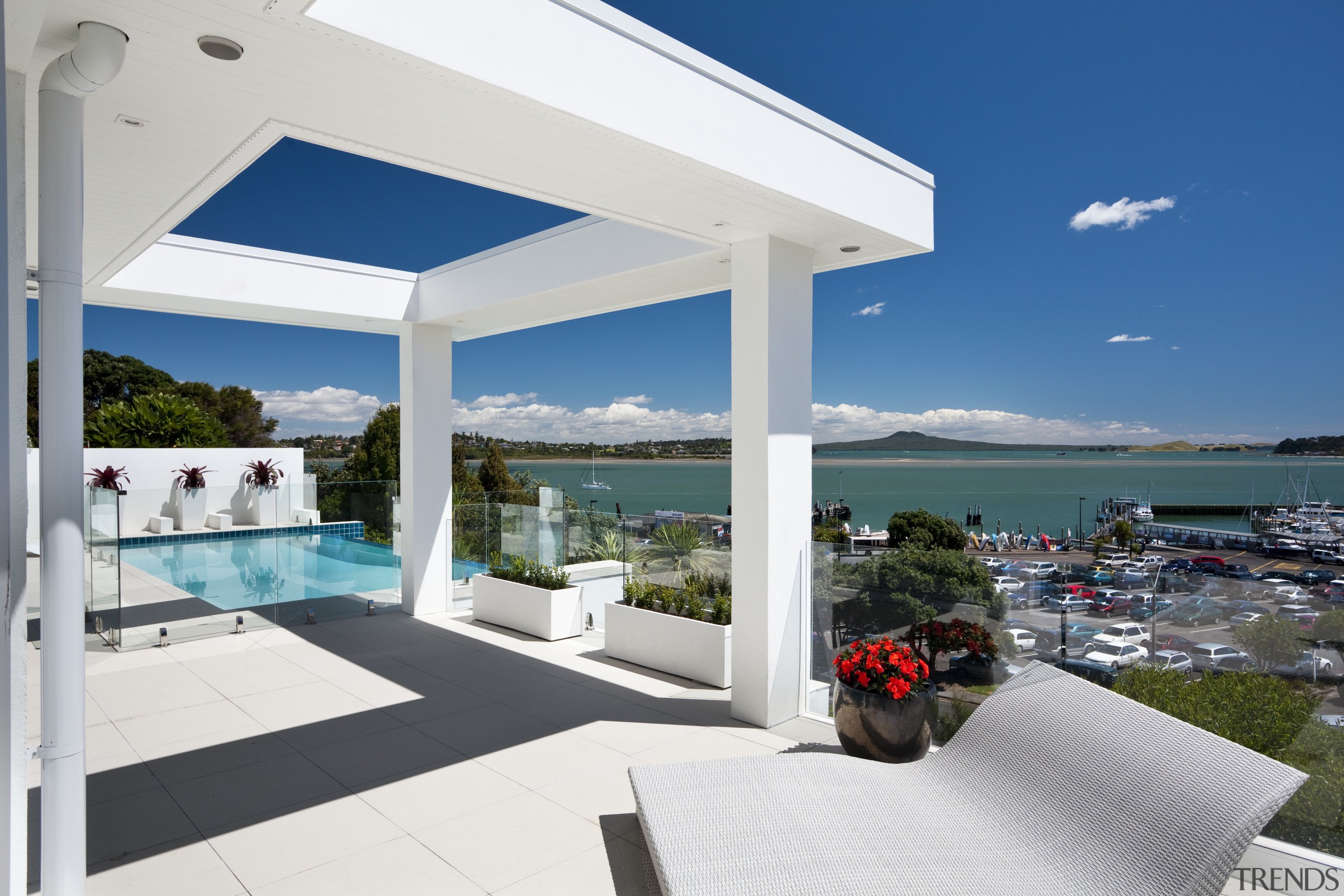 The pool beside this contemporary cliff-top house is estate, home, house, property, real estate, resort, sky, vacation, villa, white