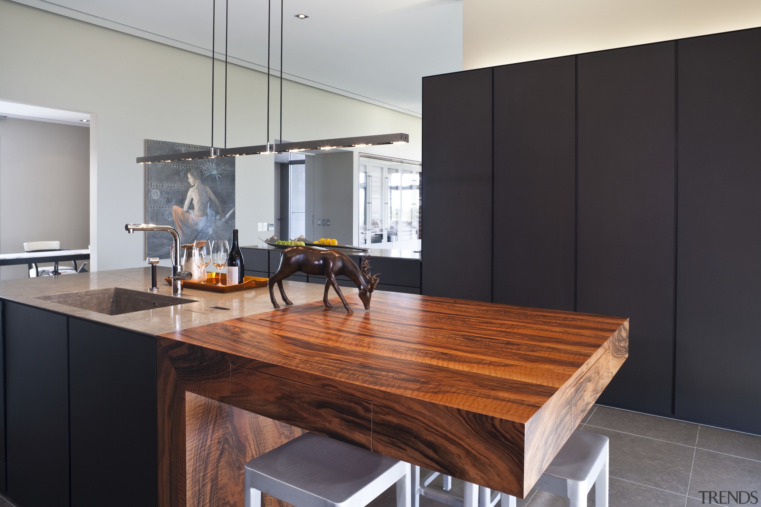 View of a contemporary kitchen which features island, countertop, furniture, interior design, kitchen, room, table, gray, black