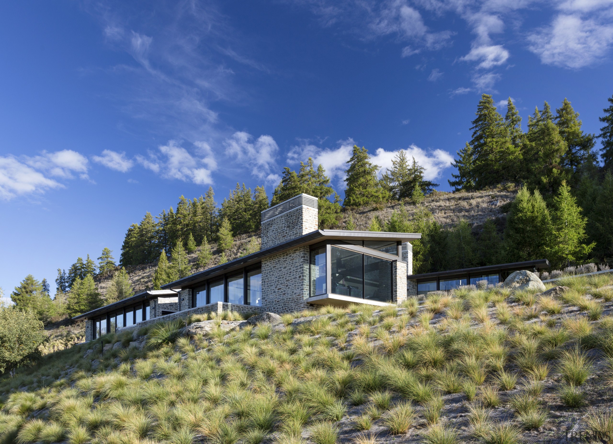 The slope of the roofs mirrors that of cloud, cottage, estate, farmhouse, home, house, hut, landscape, mountain, property, real estate, rural area, sky, tree, villa, blue