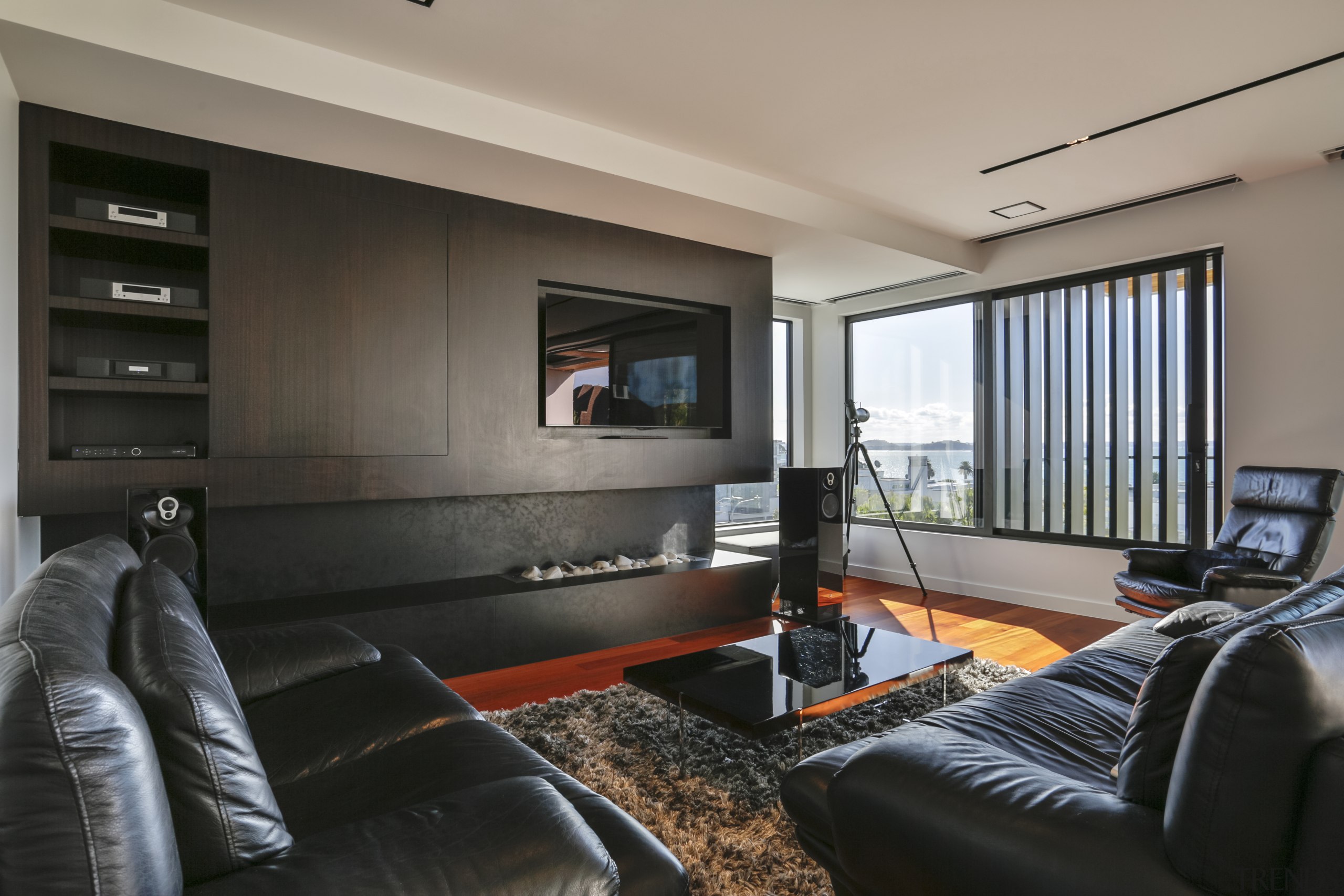 ​​​​​​​Dark living room cabinetry anchors the white, open gray, black