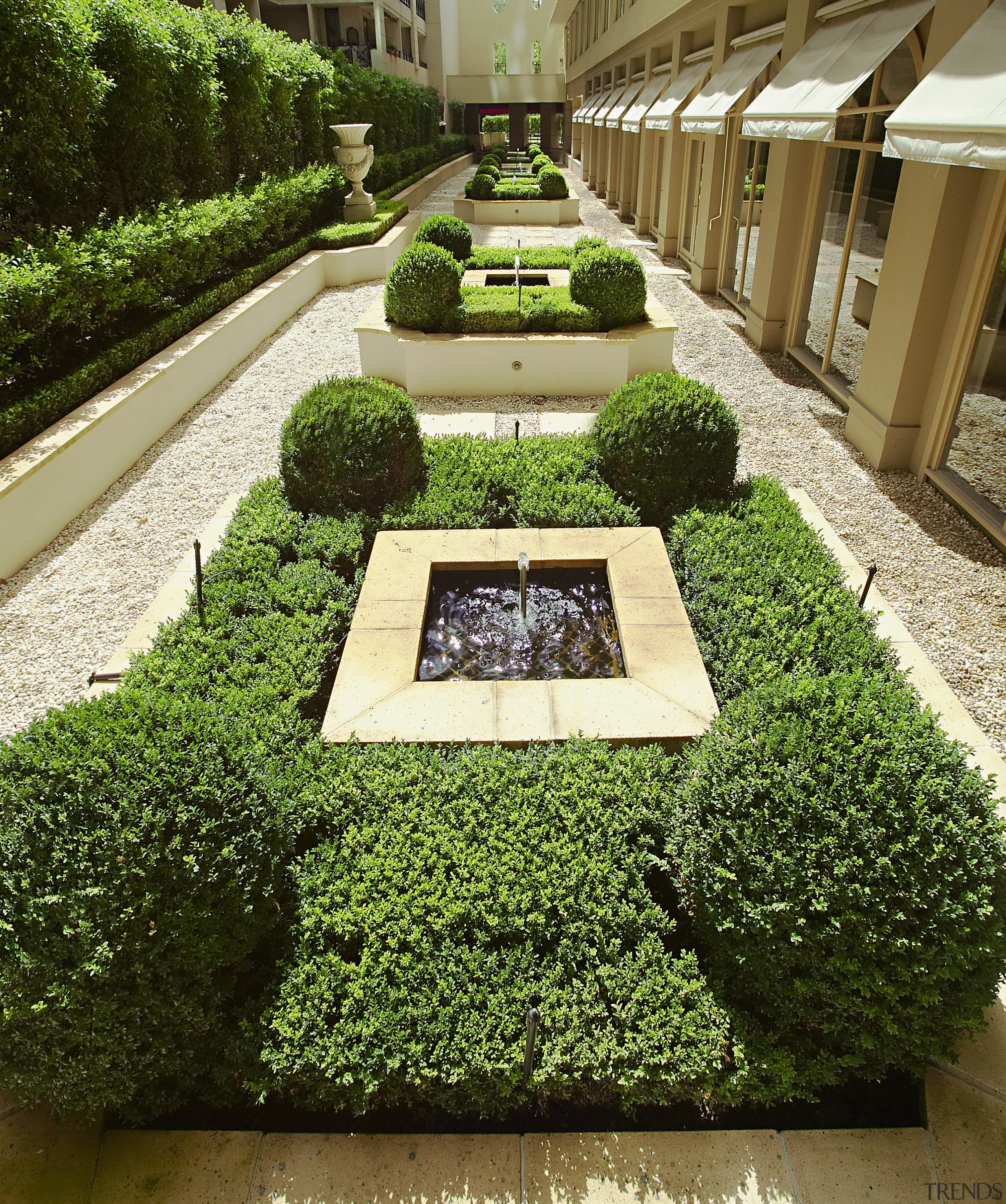 A view of a Far East Consortium apartment courtyard, garden, grass, hedge, herb, landscaping, plant, shrub, brown