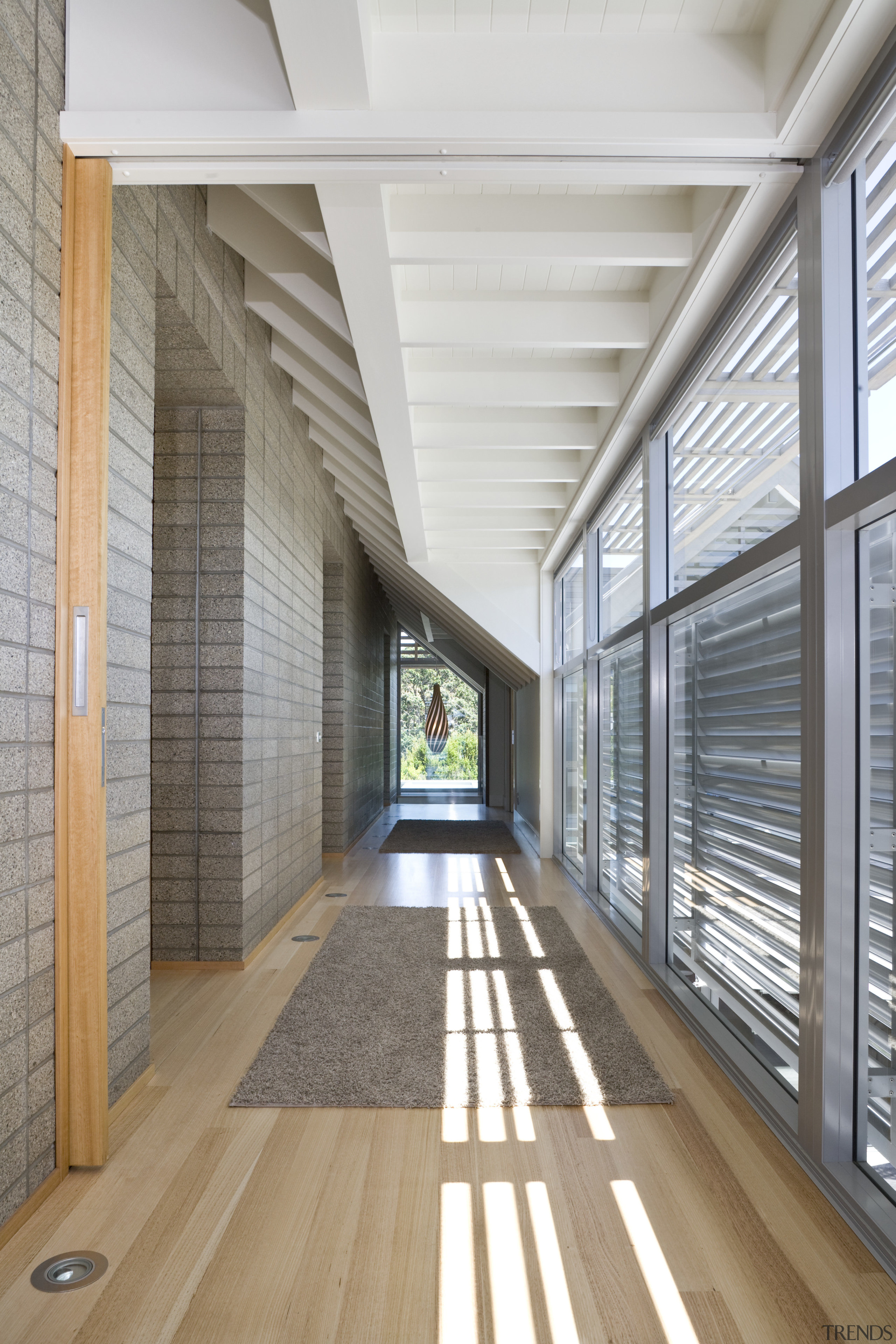 View of hallway which runs alongside the honed architecture, ceiling, daylighting, floor, flooring, house, interior design, lobby, structure, window, wood, gray