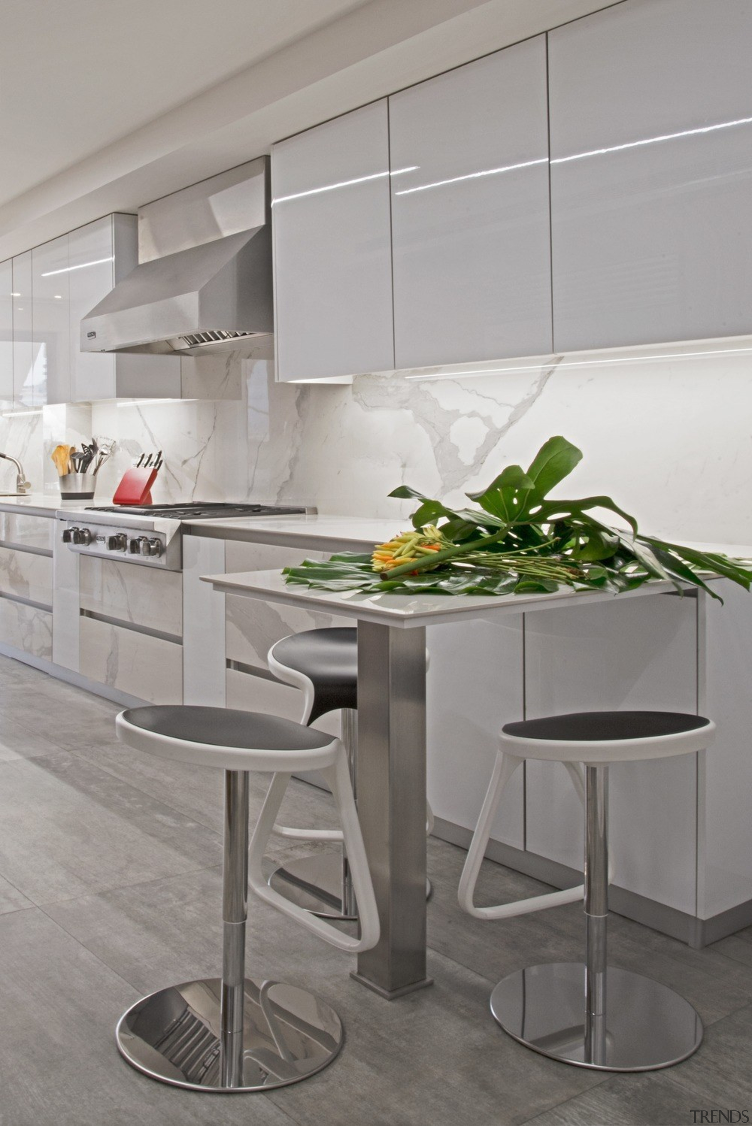 The countertop is made of engineered marble that bar stool, countertop, floor, flooring, furniture, interior design, kitchen, material property, room, stool, table, tile, white, gray