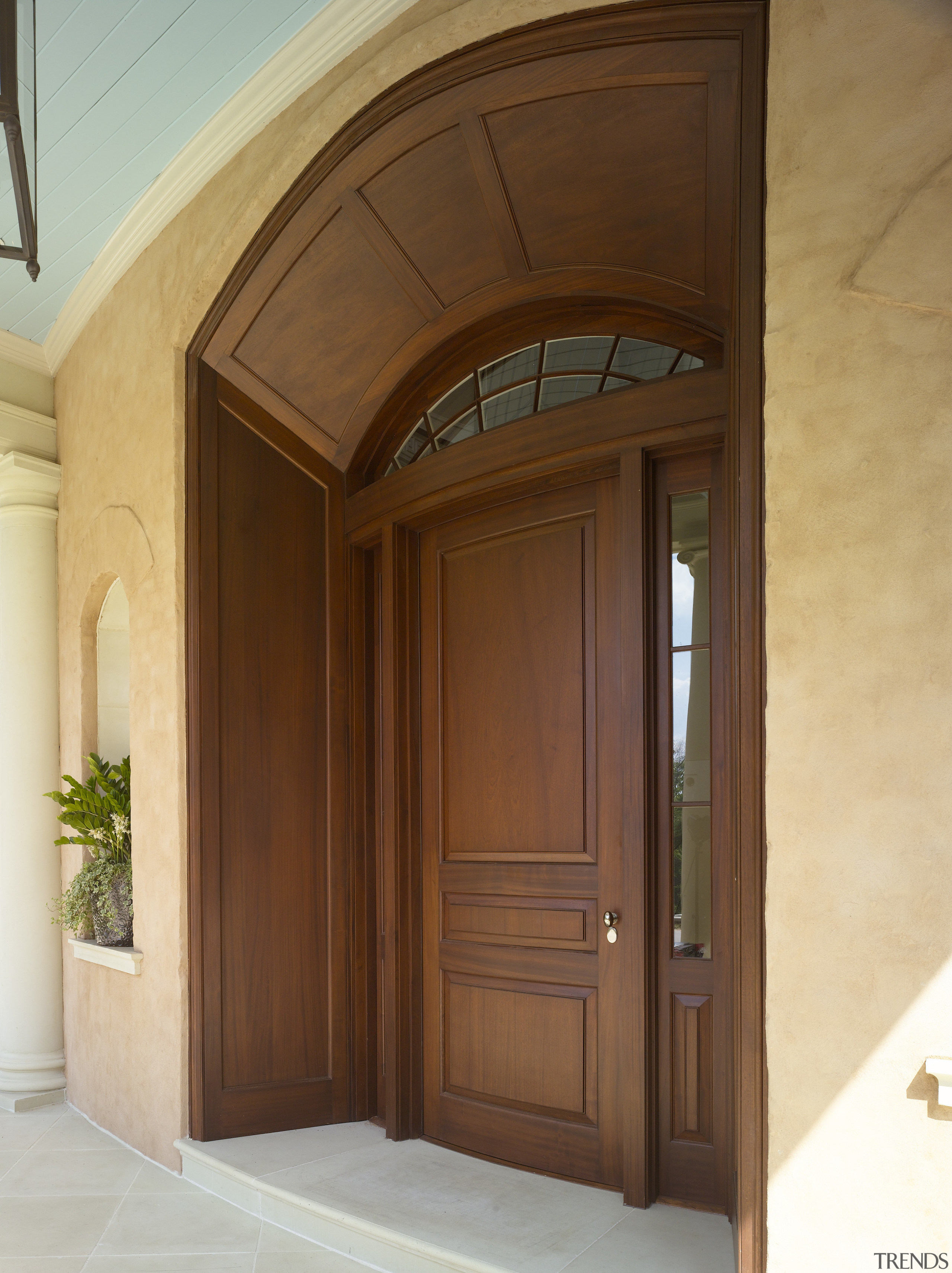 Exterior view of front door of this Regency-styled arch, door, window, wood, wood stain, brown