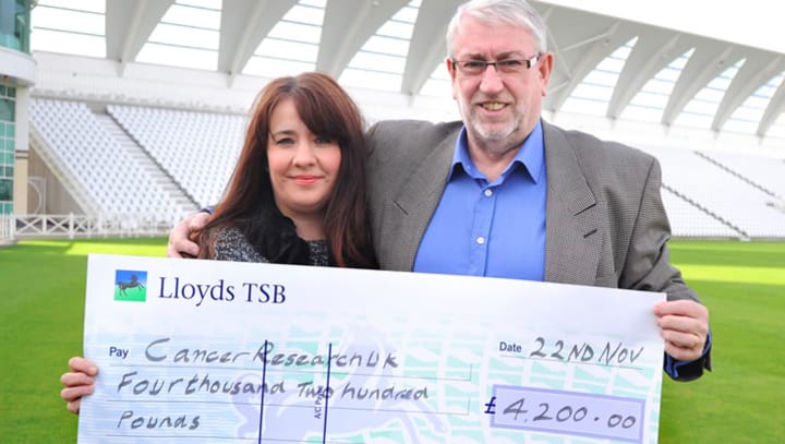 Eddie Hemmings presents the cheque to Cancer Research UK Area Manager Andrea Day at Trent Bridge