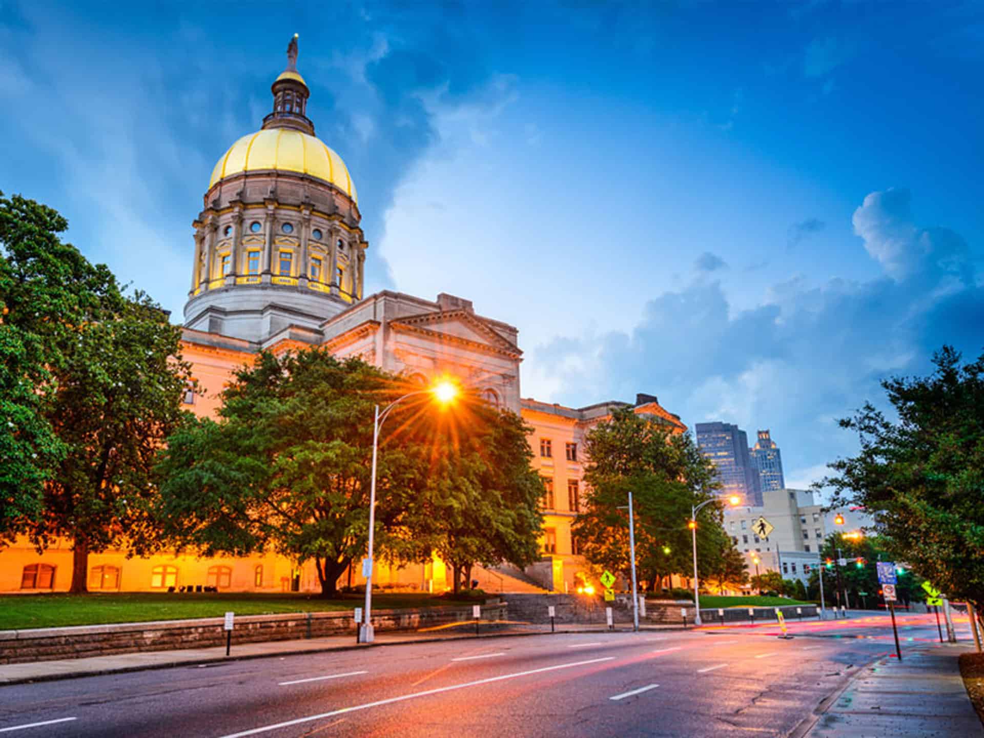 Street level view of classic style capitol building with sunburst in the forefront.