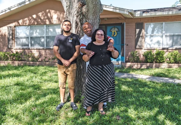 An image of smiling Tricon residents out front of their purchased home