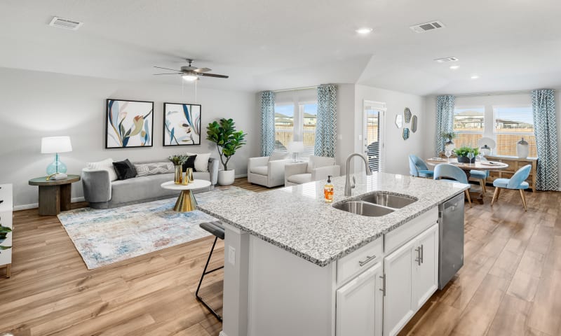 View of kitchen island with furnished living room and dining room in foreground.