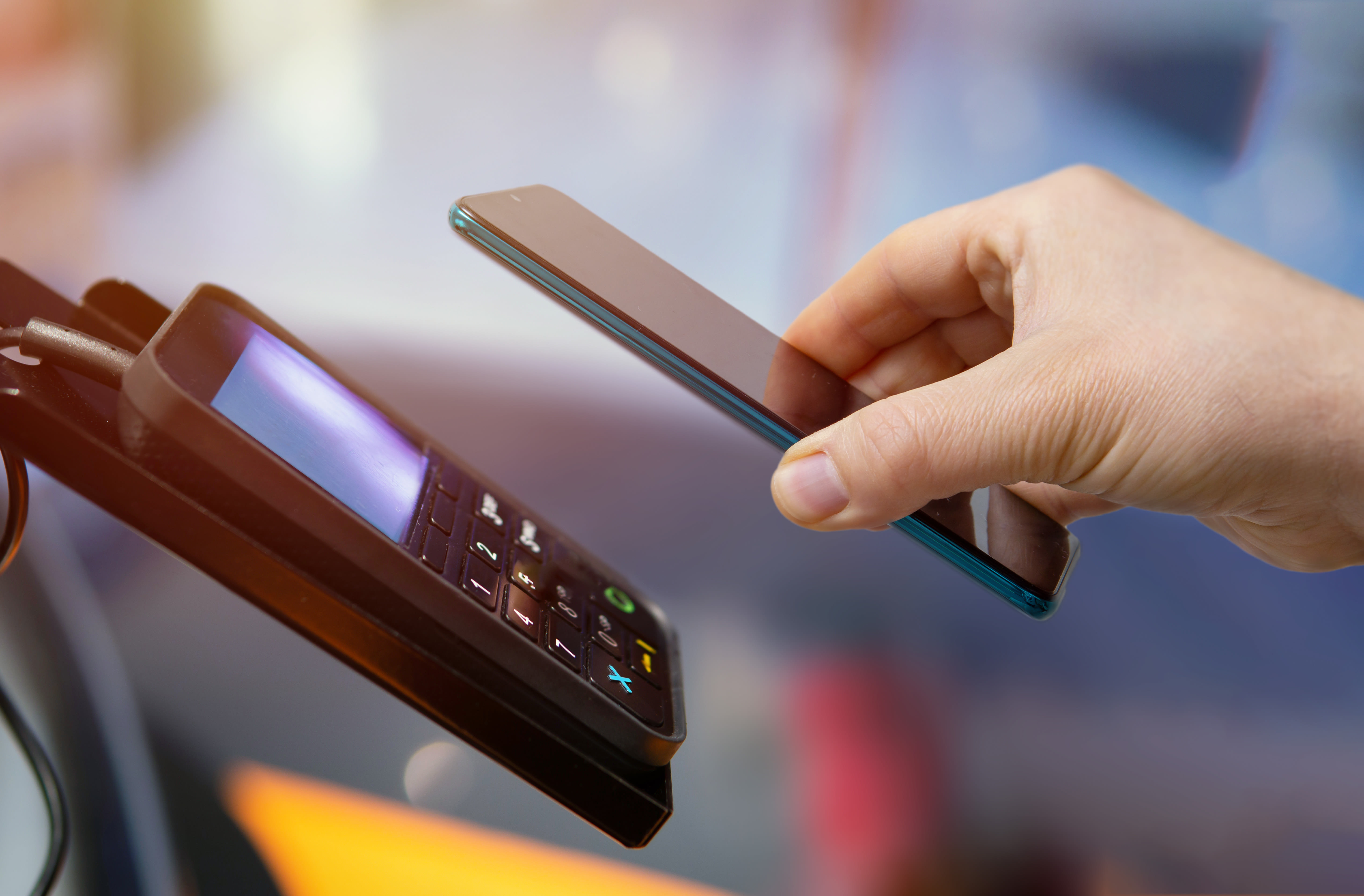 what is a virtual credit card? image of a person tapping a cell phone to a card reader