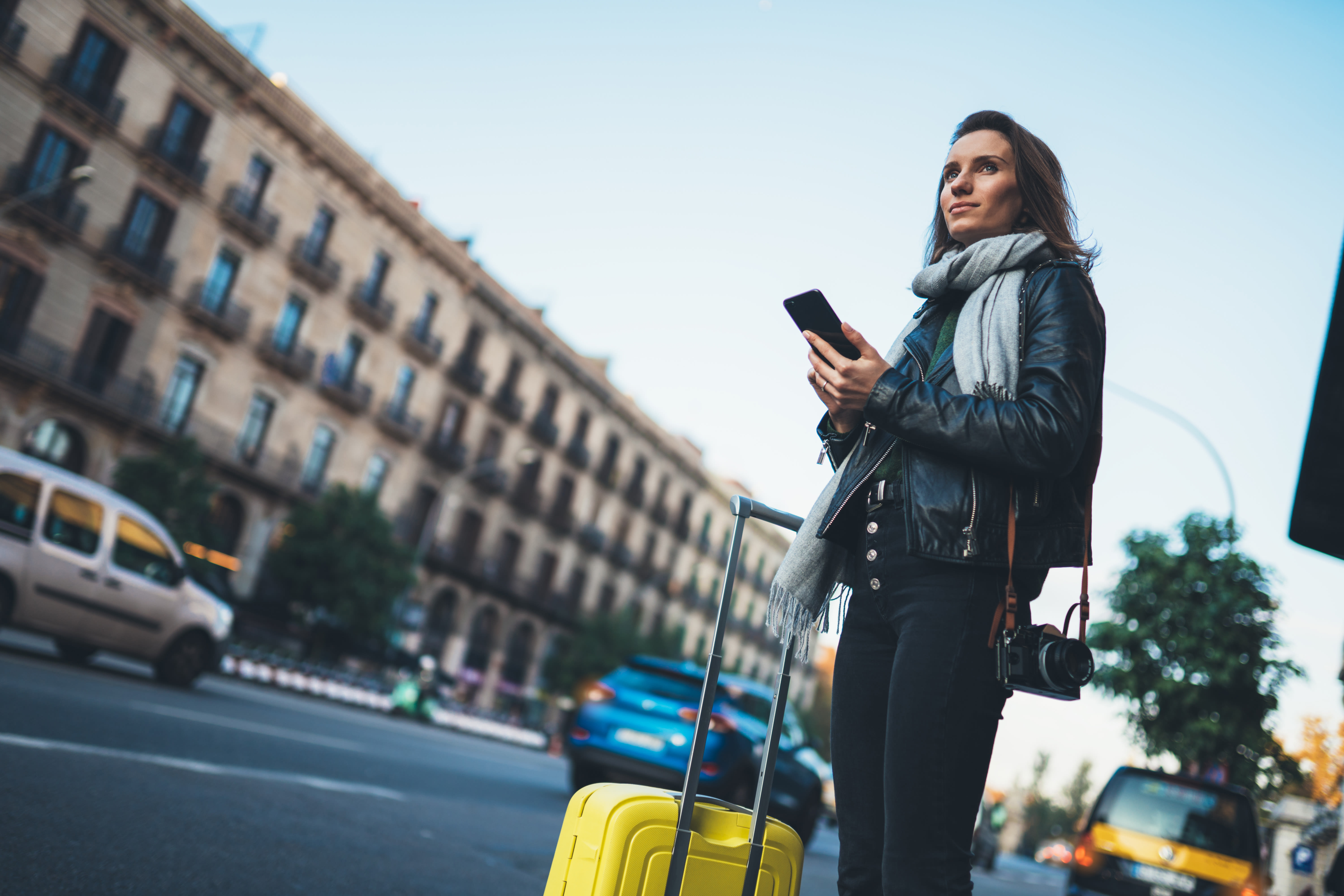 Woman traveler holding phone on busy street