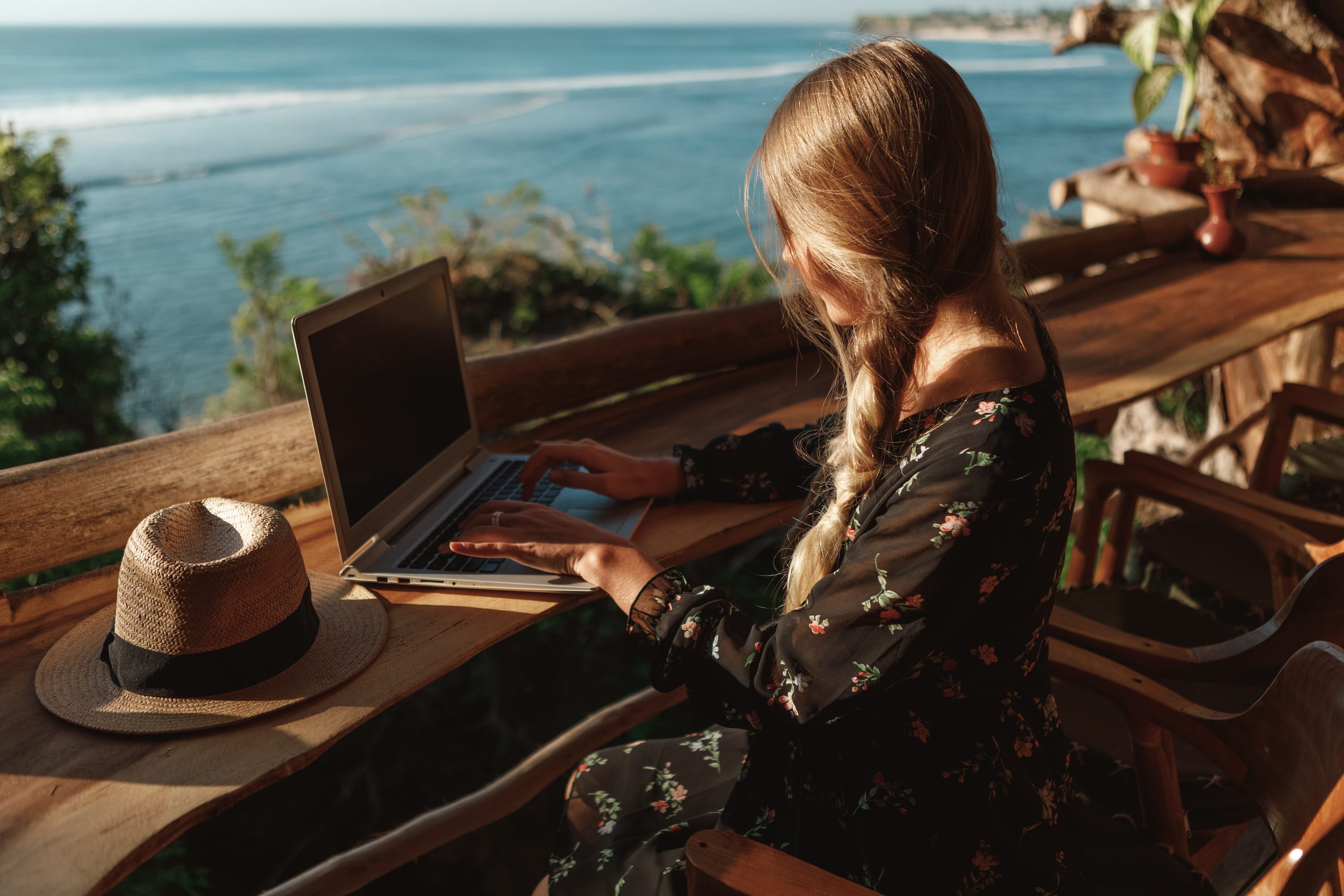 a woman on a laptop in a tropical location