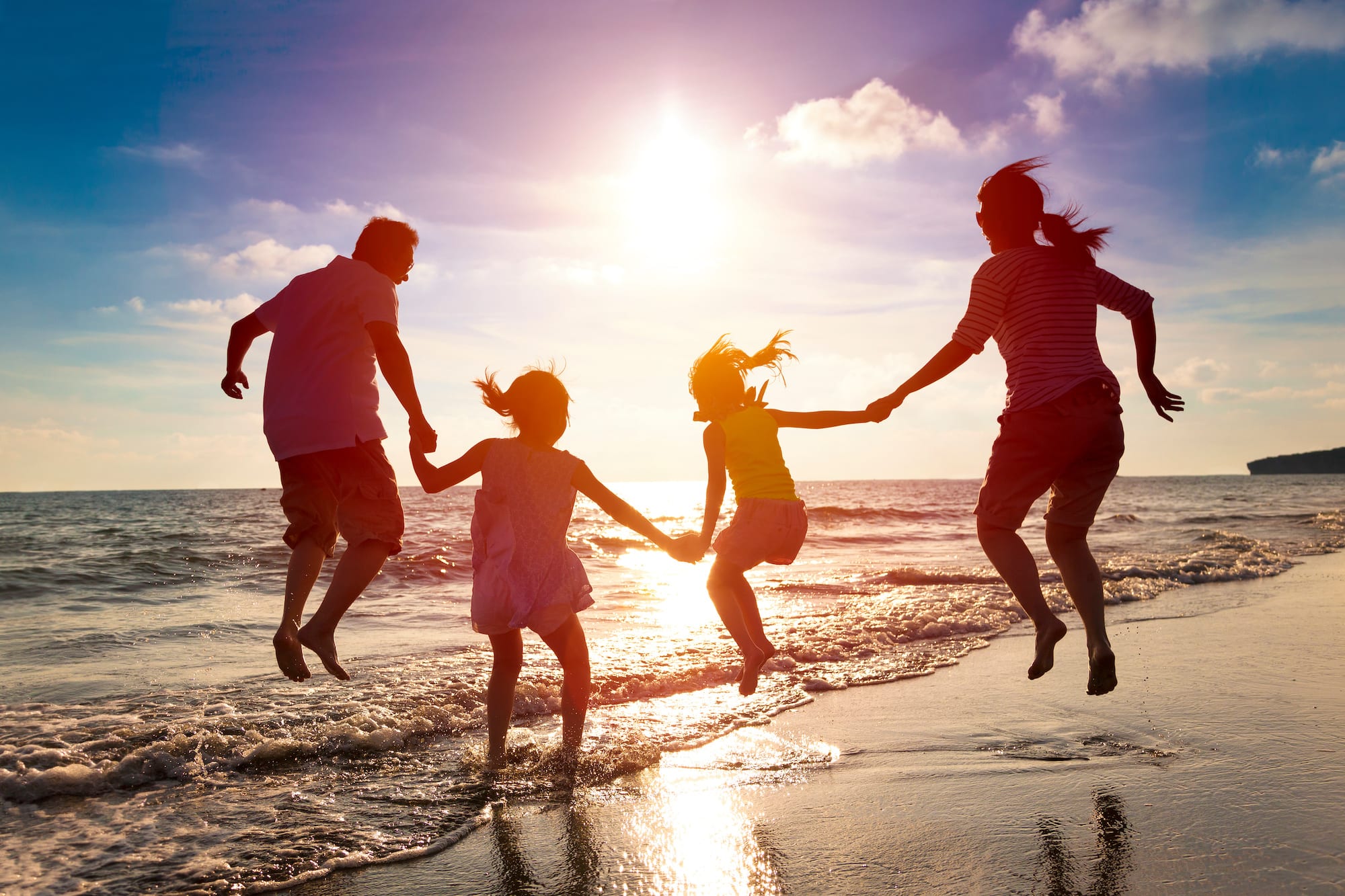 family jumping on the beach