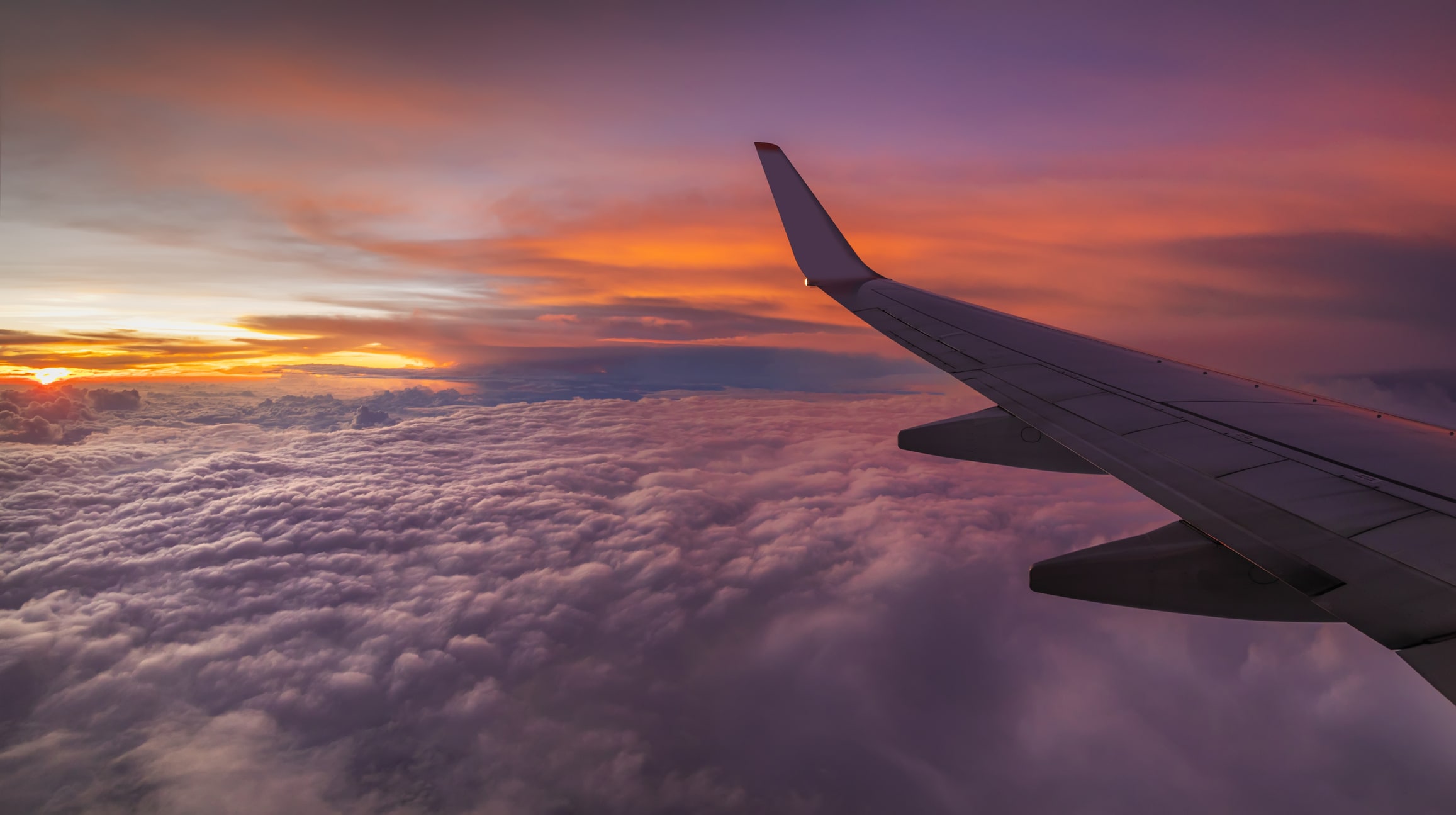 corporate travel for small business guide - airplane above clouds