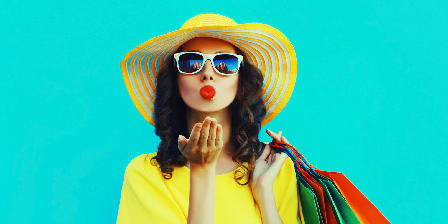 woman on a leisure trip with sunhat sunglasses and shopping bags