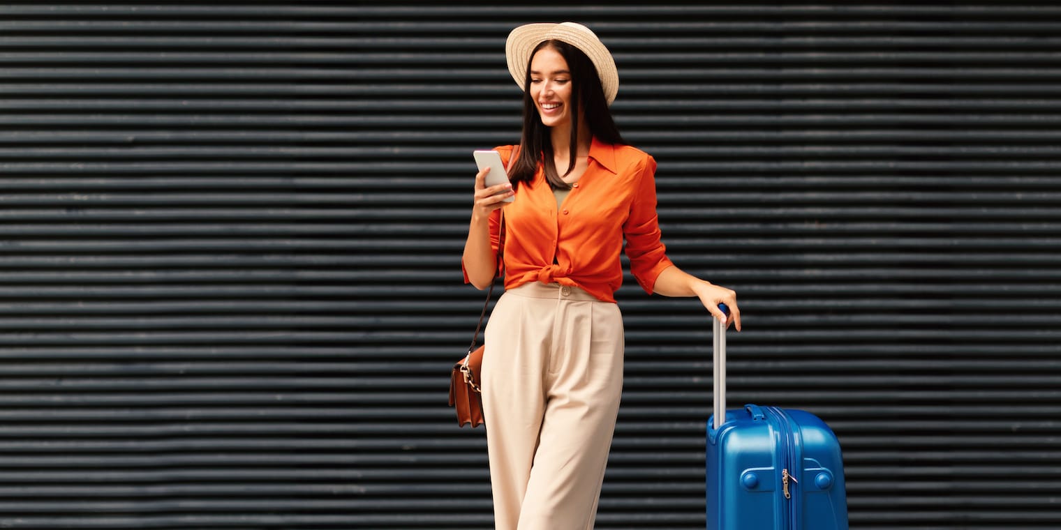 What is a hush trip? A woman on her phone with a suitcase