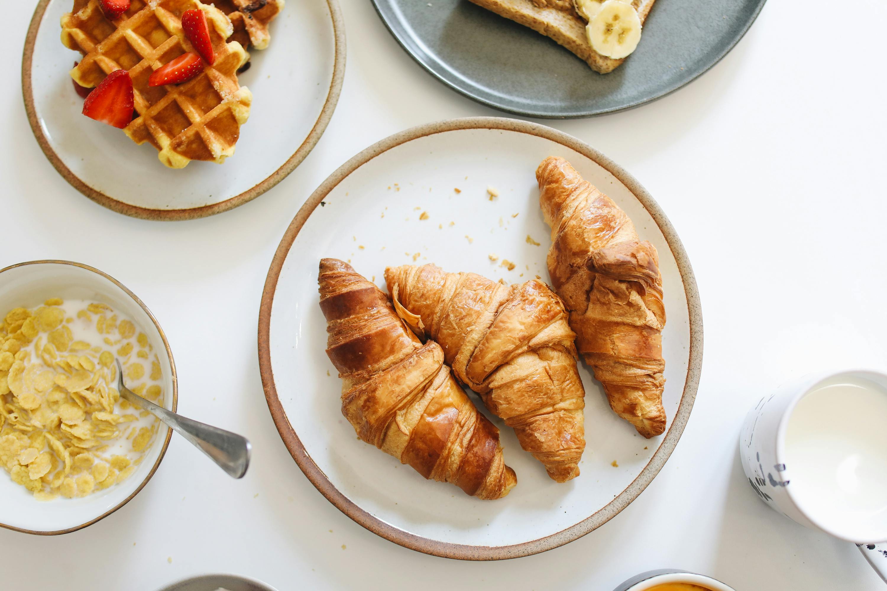 Ansprechend garnierte Croissants und Waffeln: Zahlt der Arbeitgeber für das Frühstück auf Geschäftsreise?