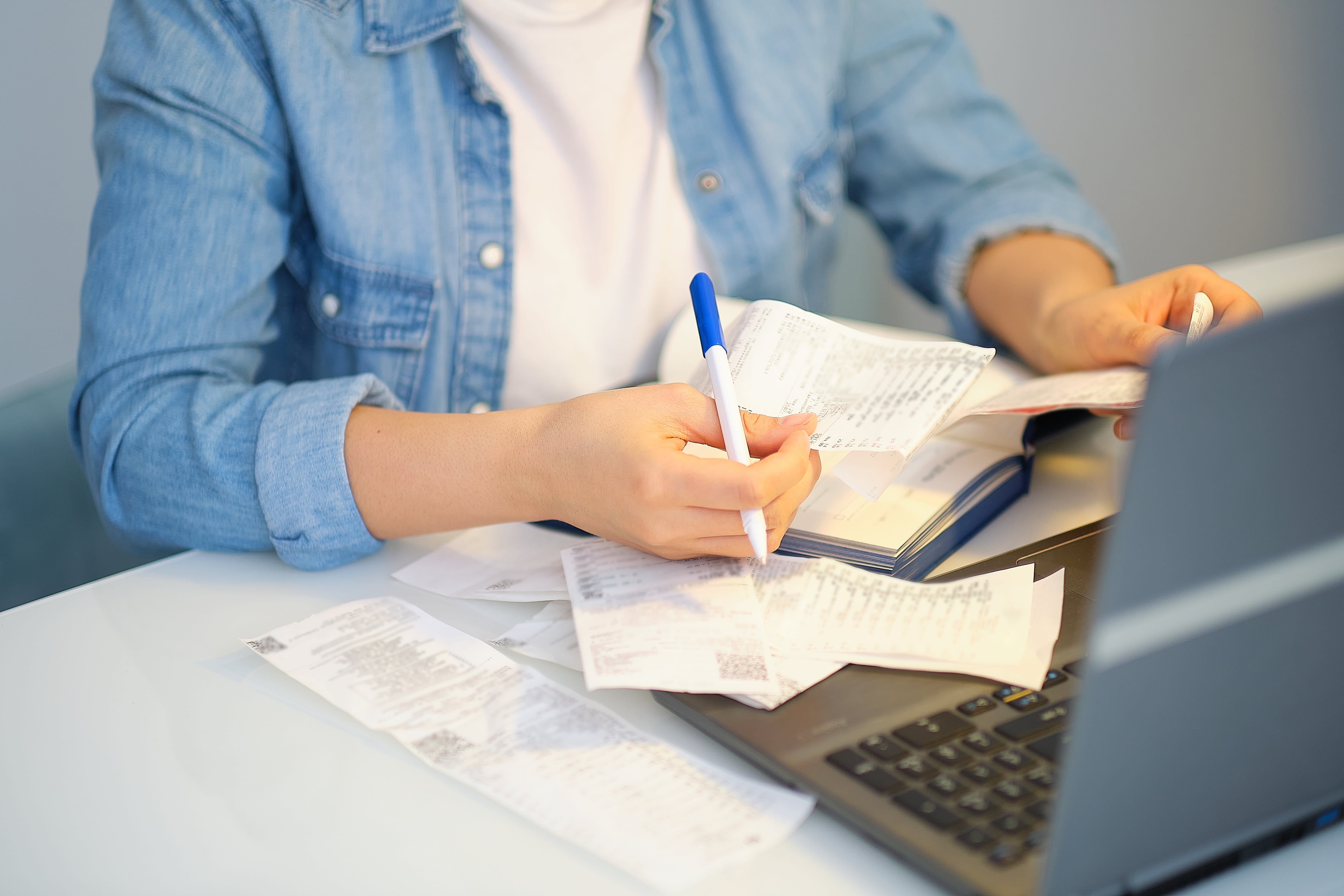 Une femme triant les justificatifs de notes de frais. Avec Navan, le remboursement des notes de frais est plus efficace.