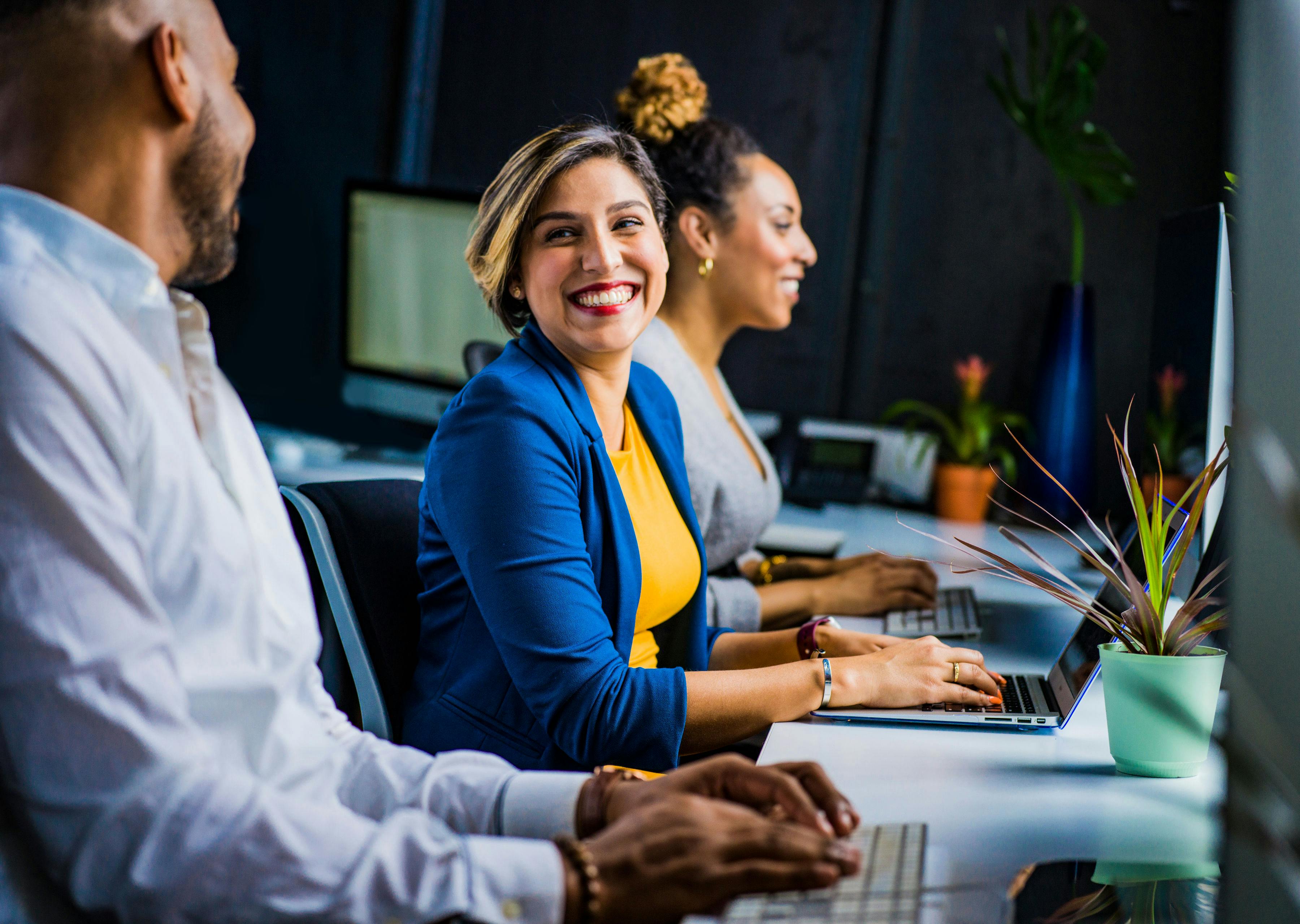 Happy executive assistants share a joke at work