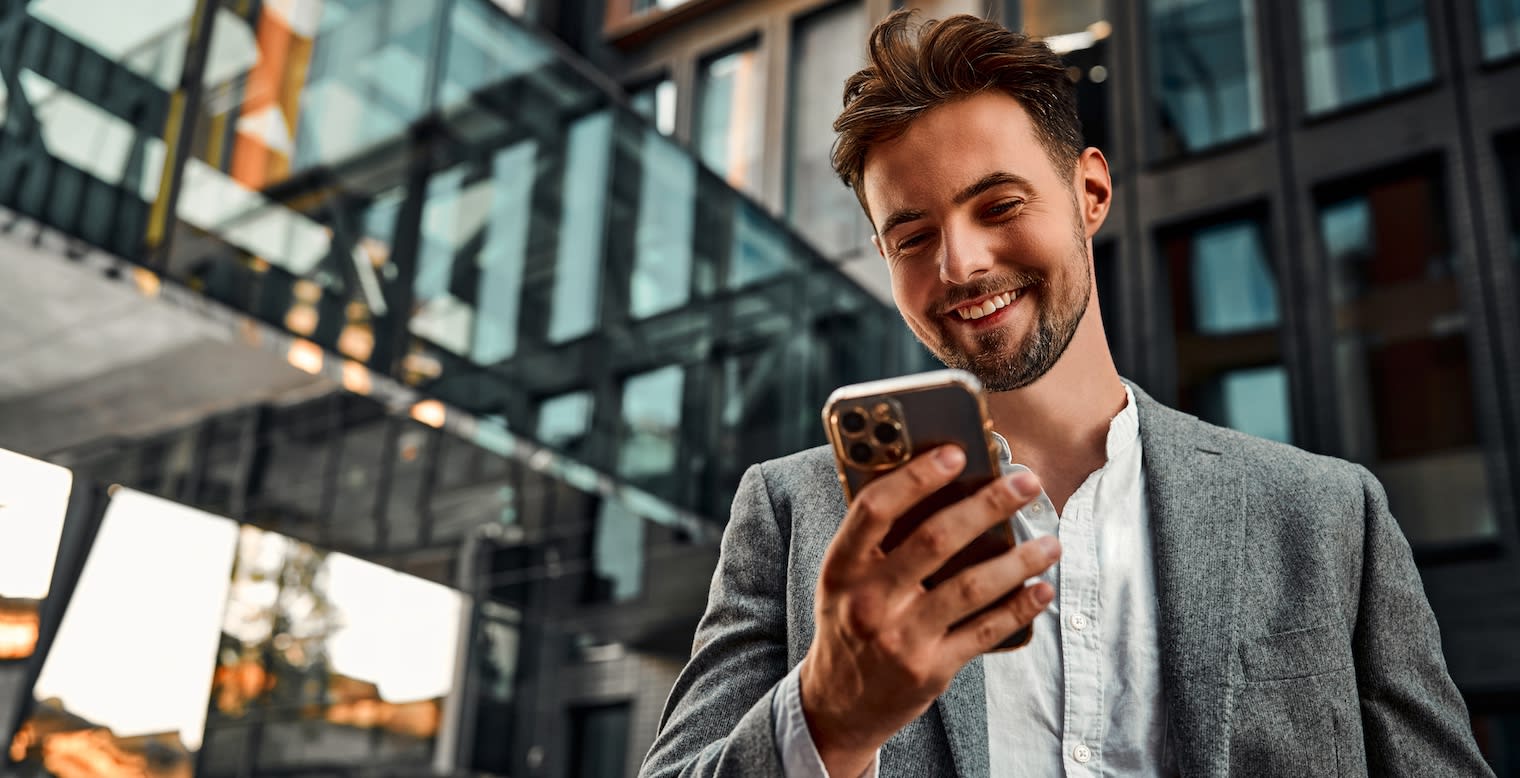 Jeune homme consultant une application de gestion des voyages d'affaires sur son smartphone