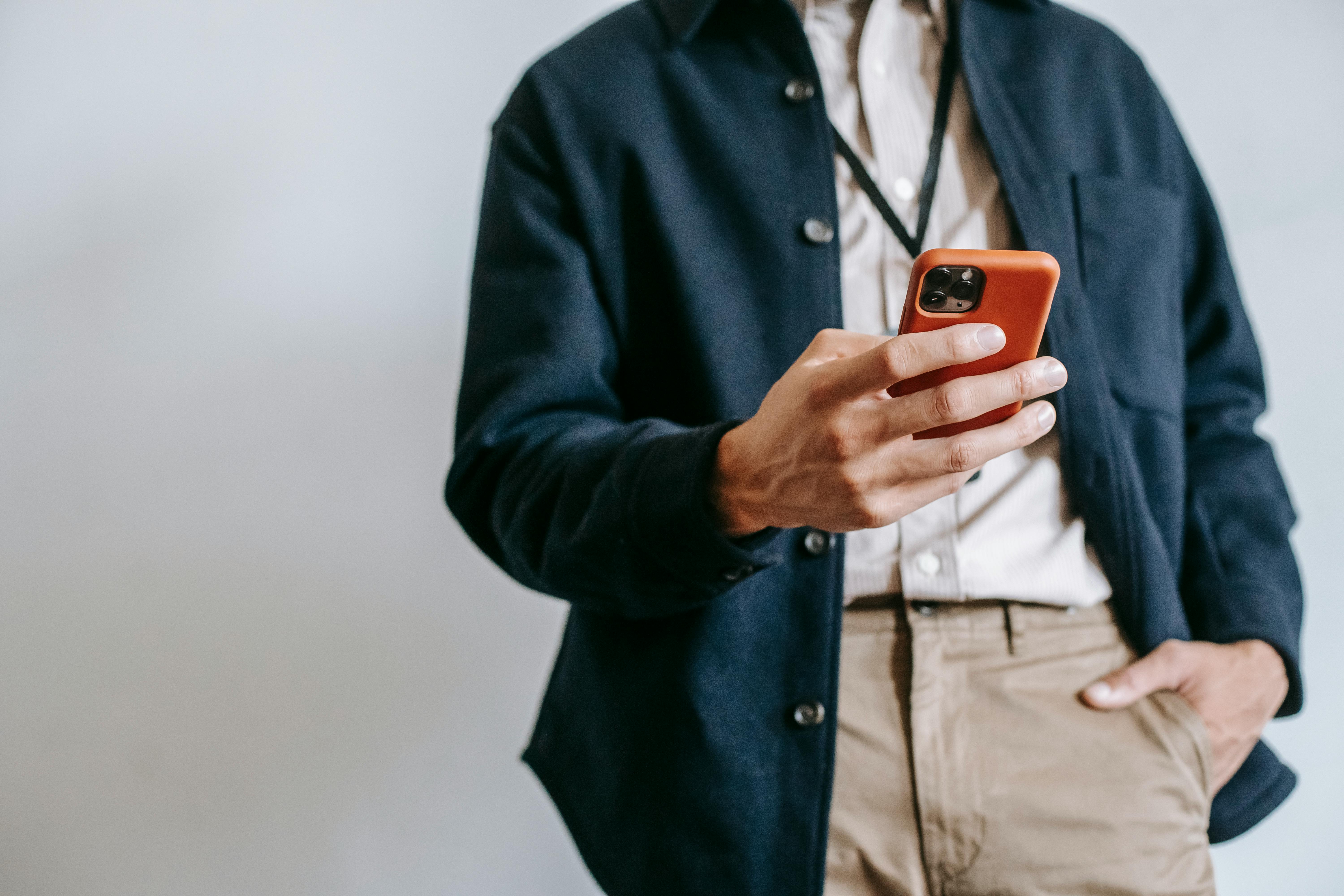 Mann am Handy, der digitale Angebote einer Reiseagentur vorzieht