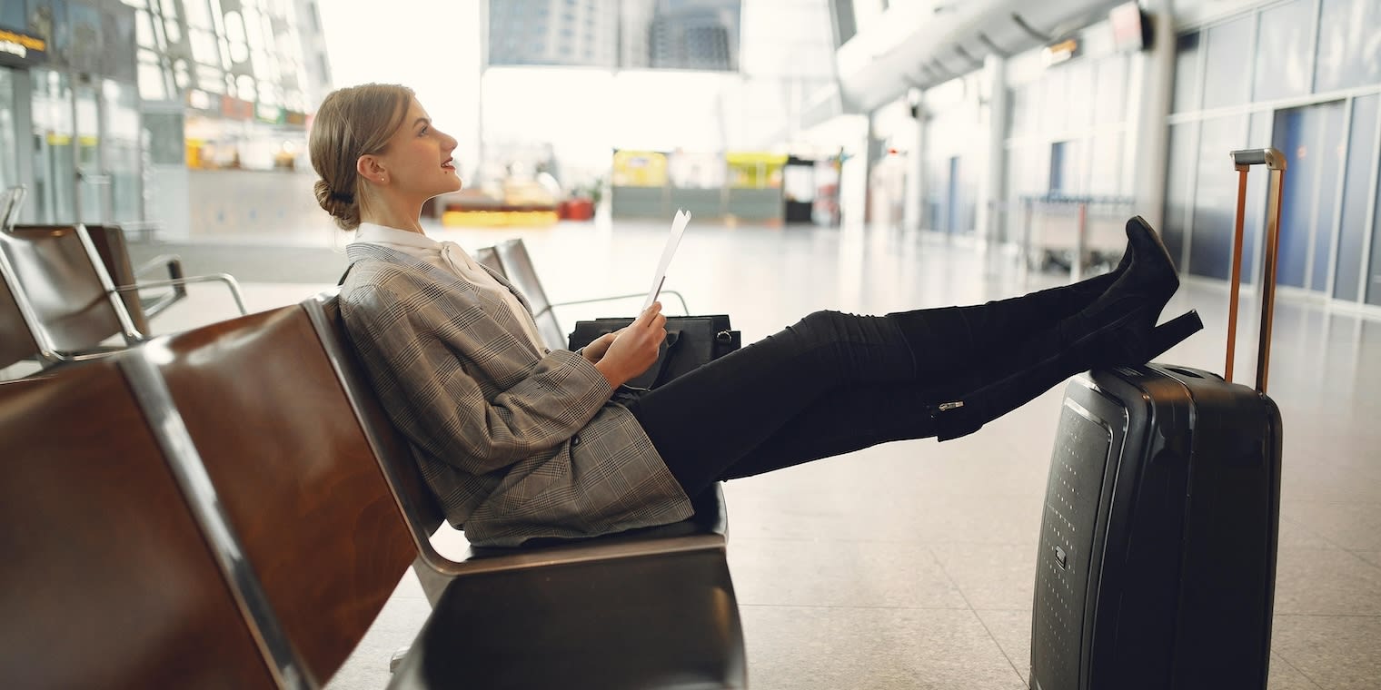 female resting legs on luggage. Global business traveller