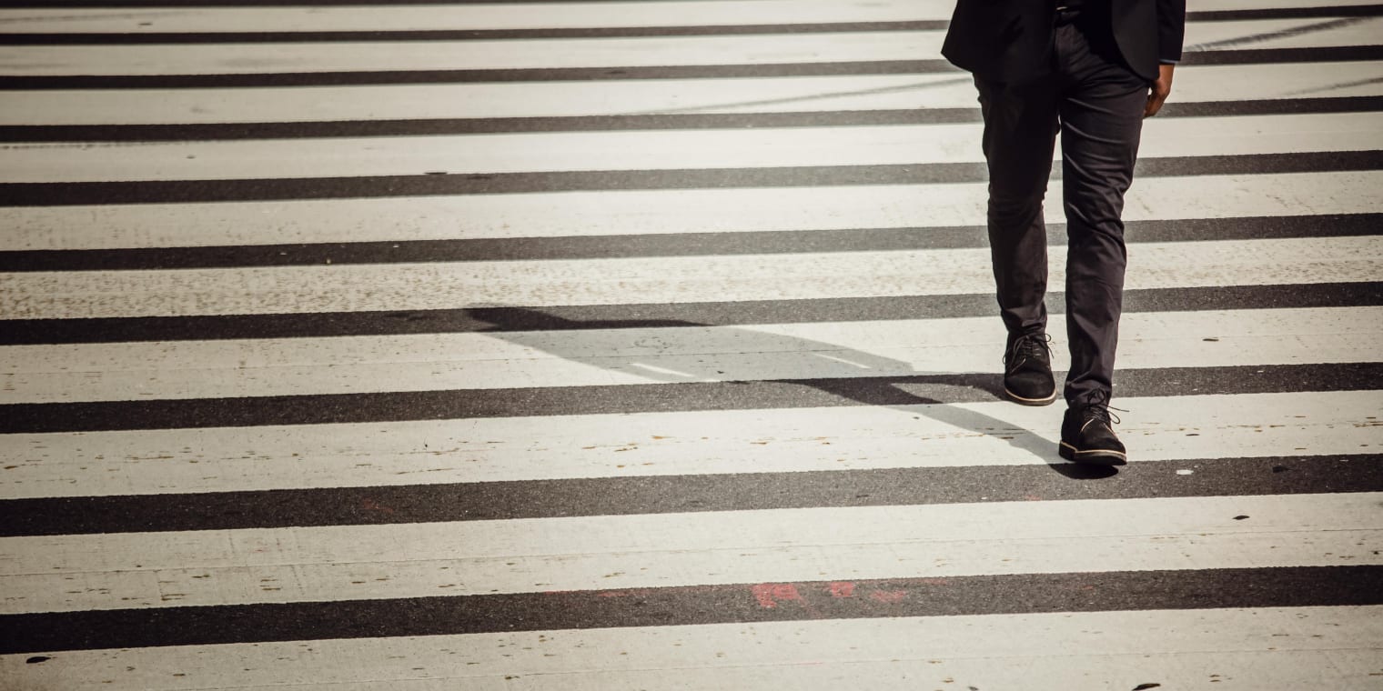 Person walking over a pedestrian crossing. Corporate travel and expense management