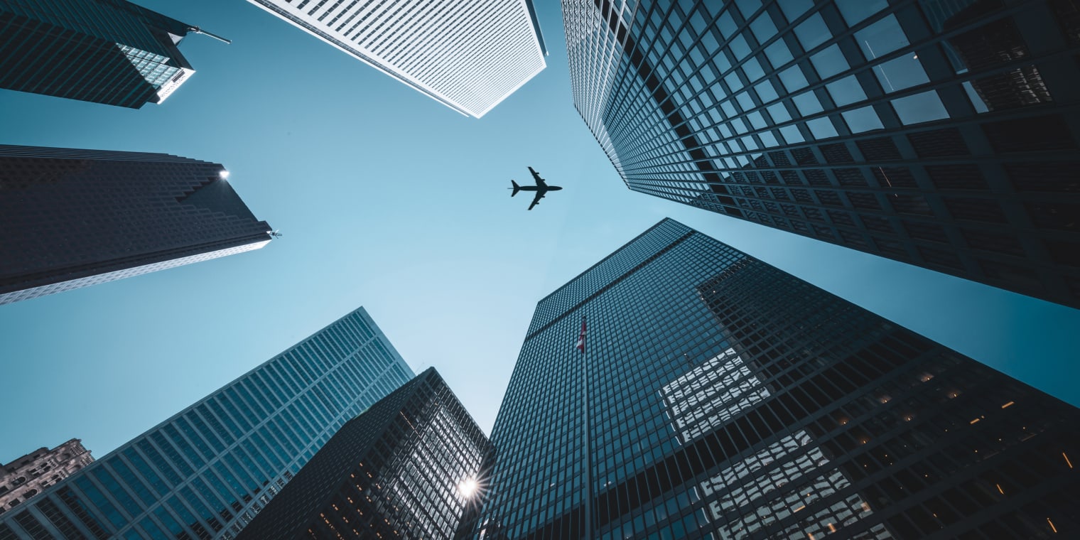 Plane flying over skyline. Corporate travel booking