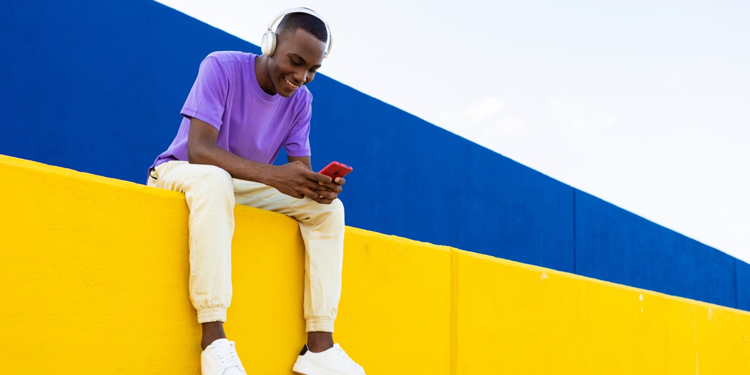expense management solutions. man wearing headset while looking at smartphone