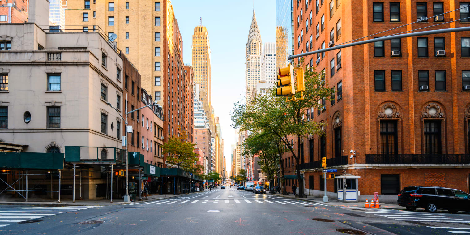 New York city crosswalk and brick buildings. Managing travel expenses. 