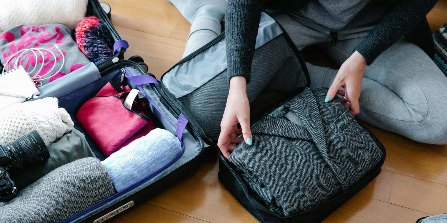 Ein Koffer wird mit Geschäftsreise-Packliste gepackt.