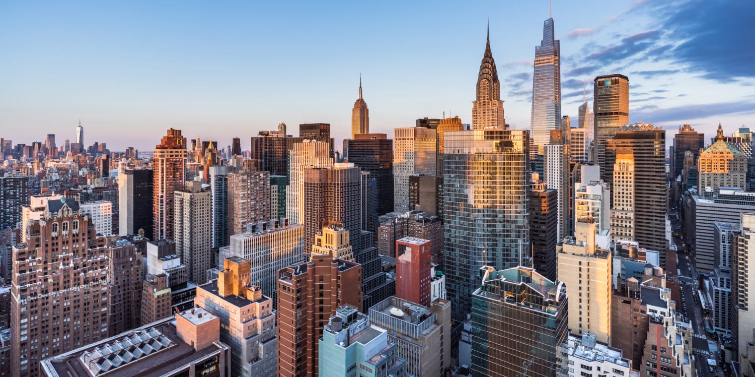 Buildings on city skyline with sunshine. Corporate travel discounts