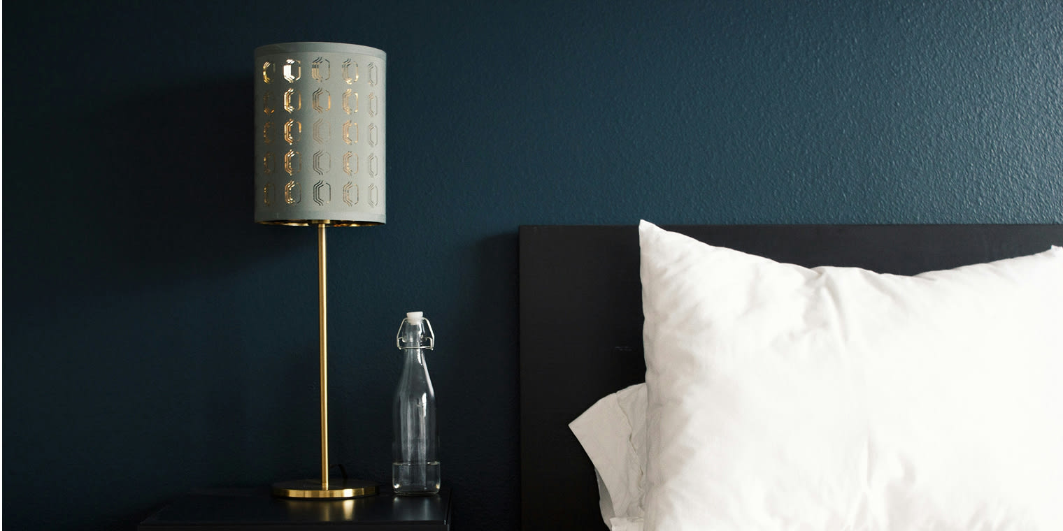 Das Hotelzimmer mit dunkelblauer Wand und weißem Bettbezug lässt sich mit Corporate Rate noch mehr genießen.