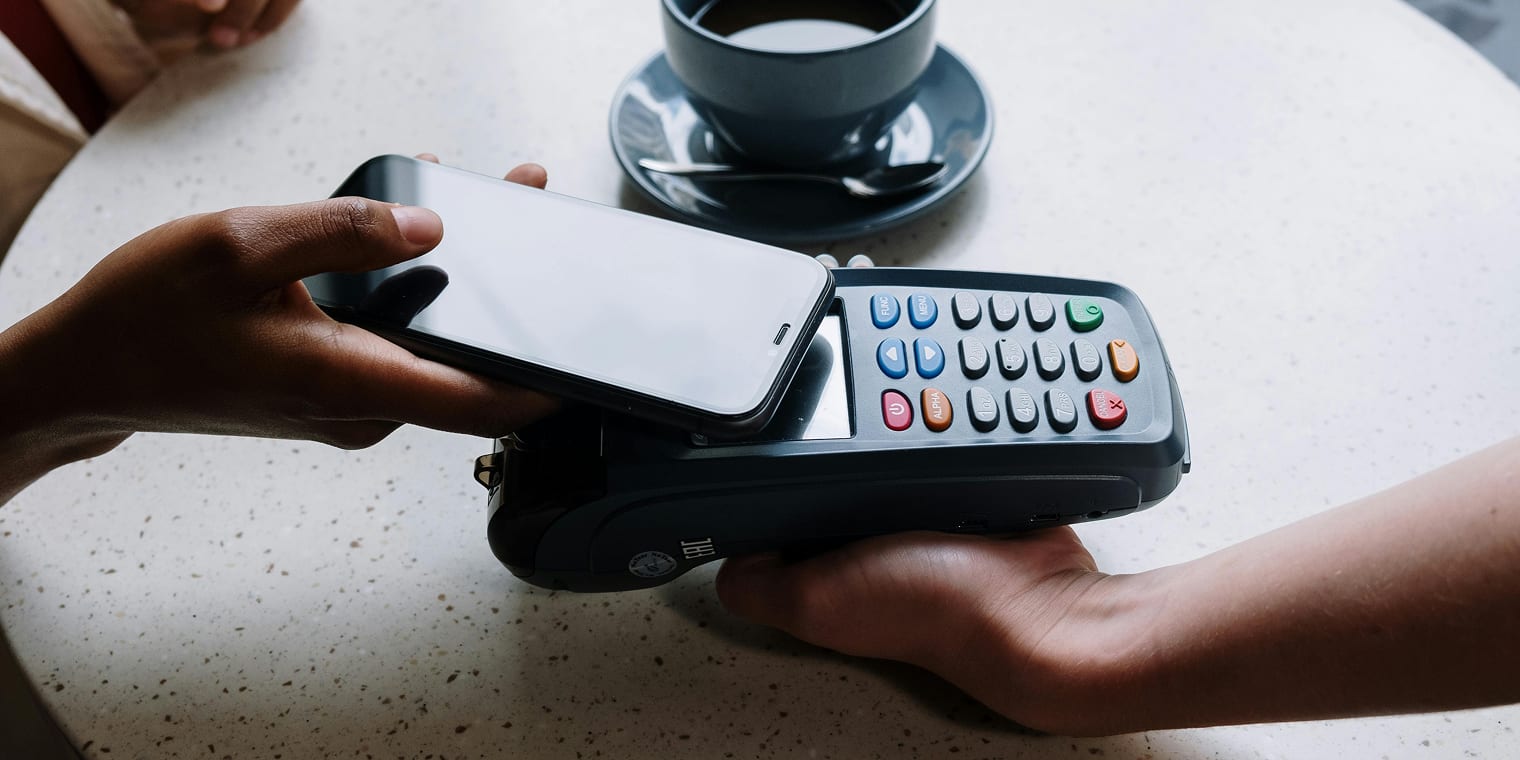 Eine Person bezahlt bequem kontaktlos mit Handy mit ihrer Per Diem Tagespauschale.