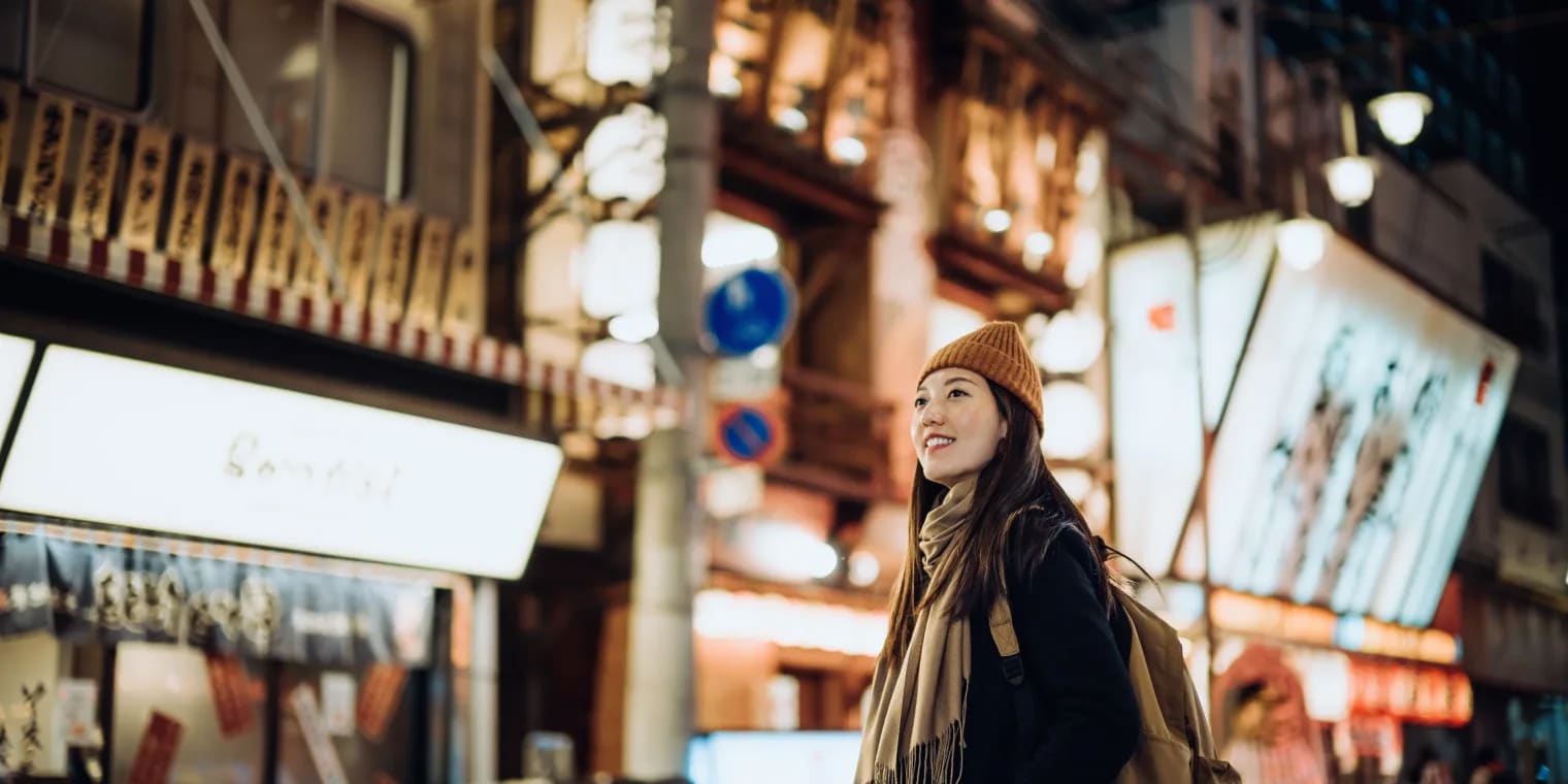 Eine junge, asiatische Frau mit orangenem Beanie wurde von ihrem Unternehmen auf Incentive-Reisen nach Japan geschickt. 