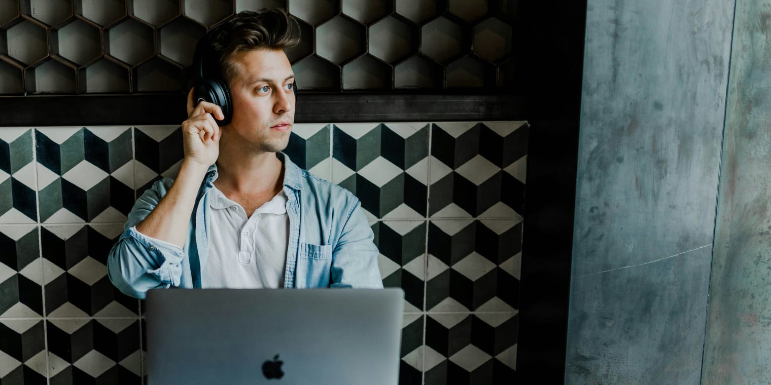 Mithilfe eines Online-Reisebüros hat dieser junge, blonde Mann im blauen Hemd seine Reise in kürzester Zeit geplant.