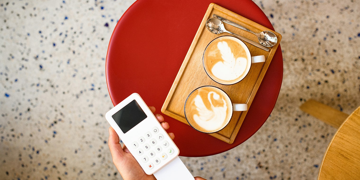 Auch beim Bezahlen von zwei Kaffee auf einem roten Tisch kann es zu Kreditkartenbetrug kommen.
