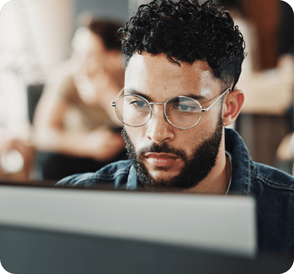 Homme avec lunettes travaillant sur un ordinateur