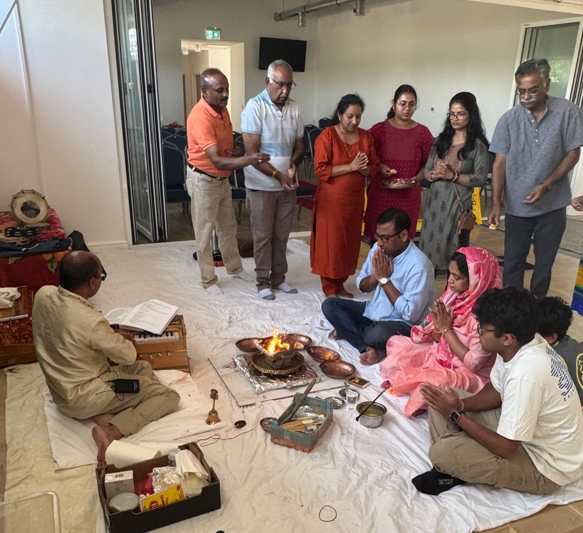 Devotees gathered around the sacred fire during the monthly havan