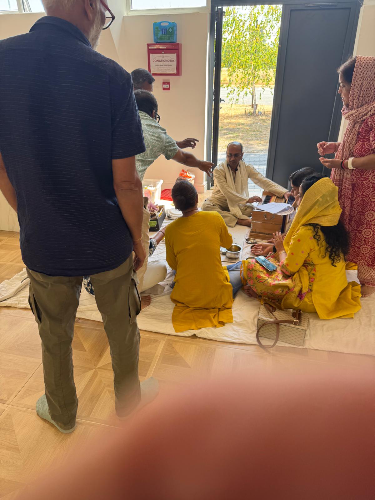Devotees gathered around the sacred fire during the monthly havan