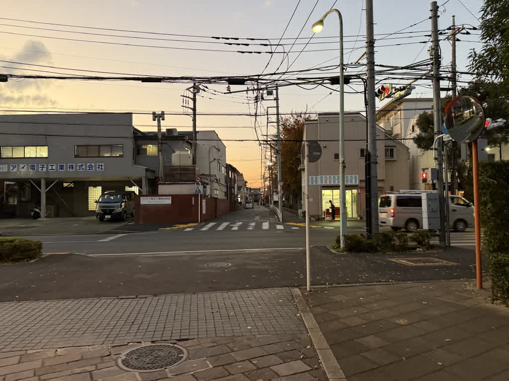 夕暮れ時の交差点。信号や電線が見える