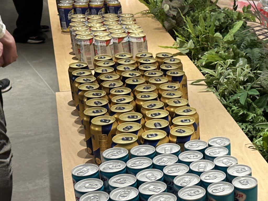 テーブルに並べられた缶ビールと緑の植物。