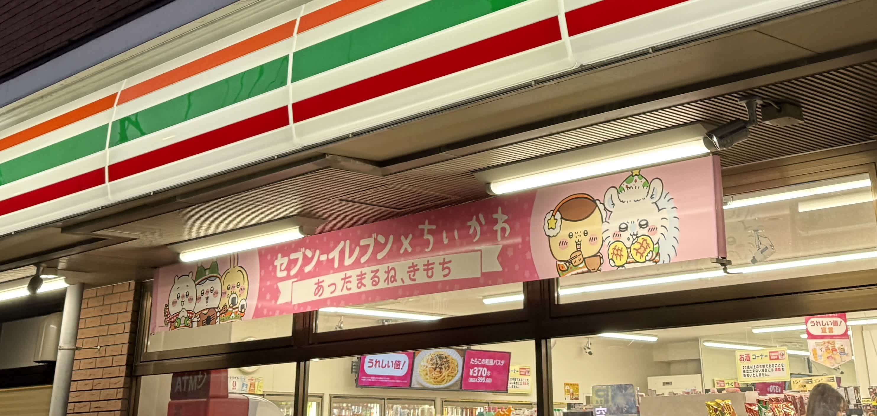 セブンイレブンの店先にかかっている、セブンイレブンとちいかわのコラボ横断幕。モモンガがメロンパンを食べているイラストが描かれている